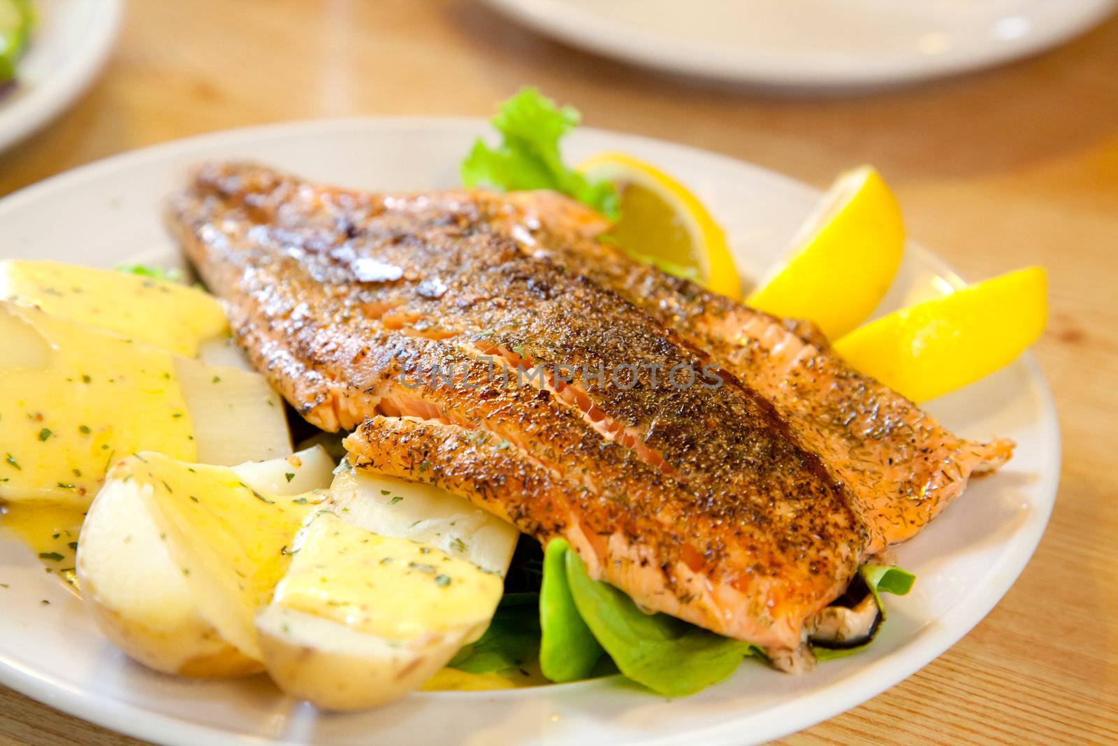 gourmet Grilled Salmon Steak with baked potato and lemon meal