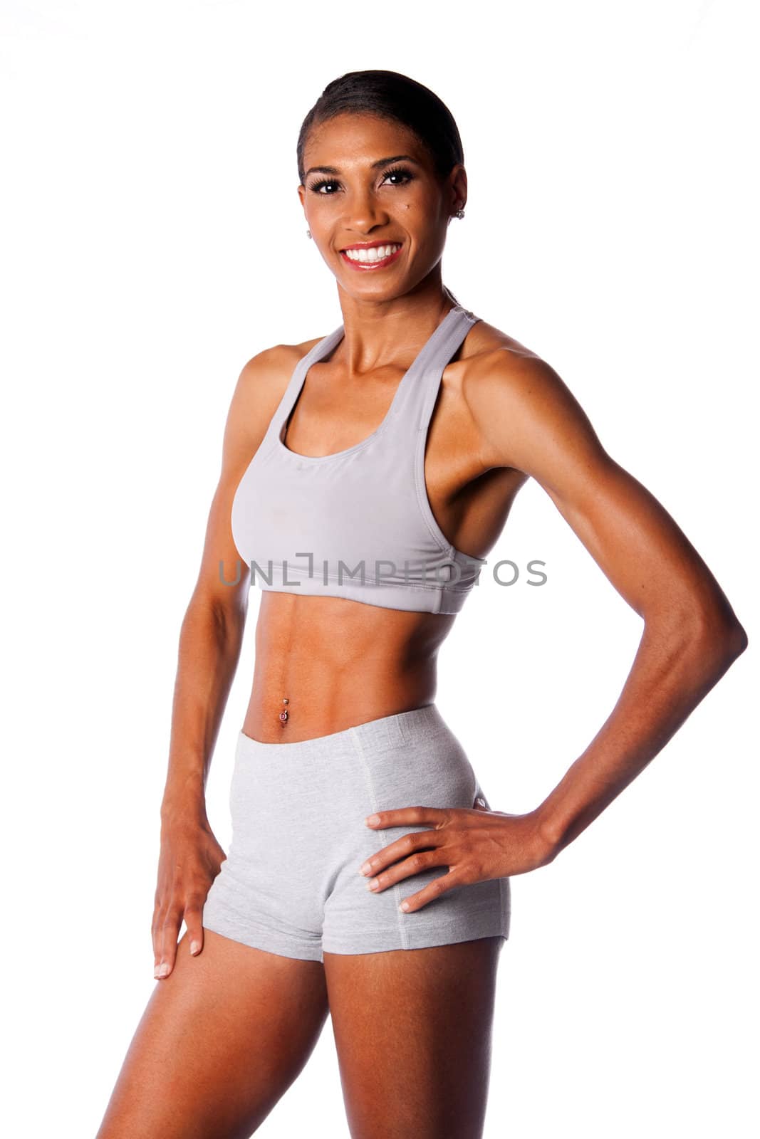 Beautiful toned muscular fitness body of happy smiling African female athlete in grey, isolated.