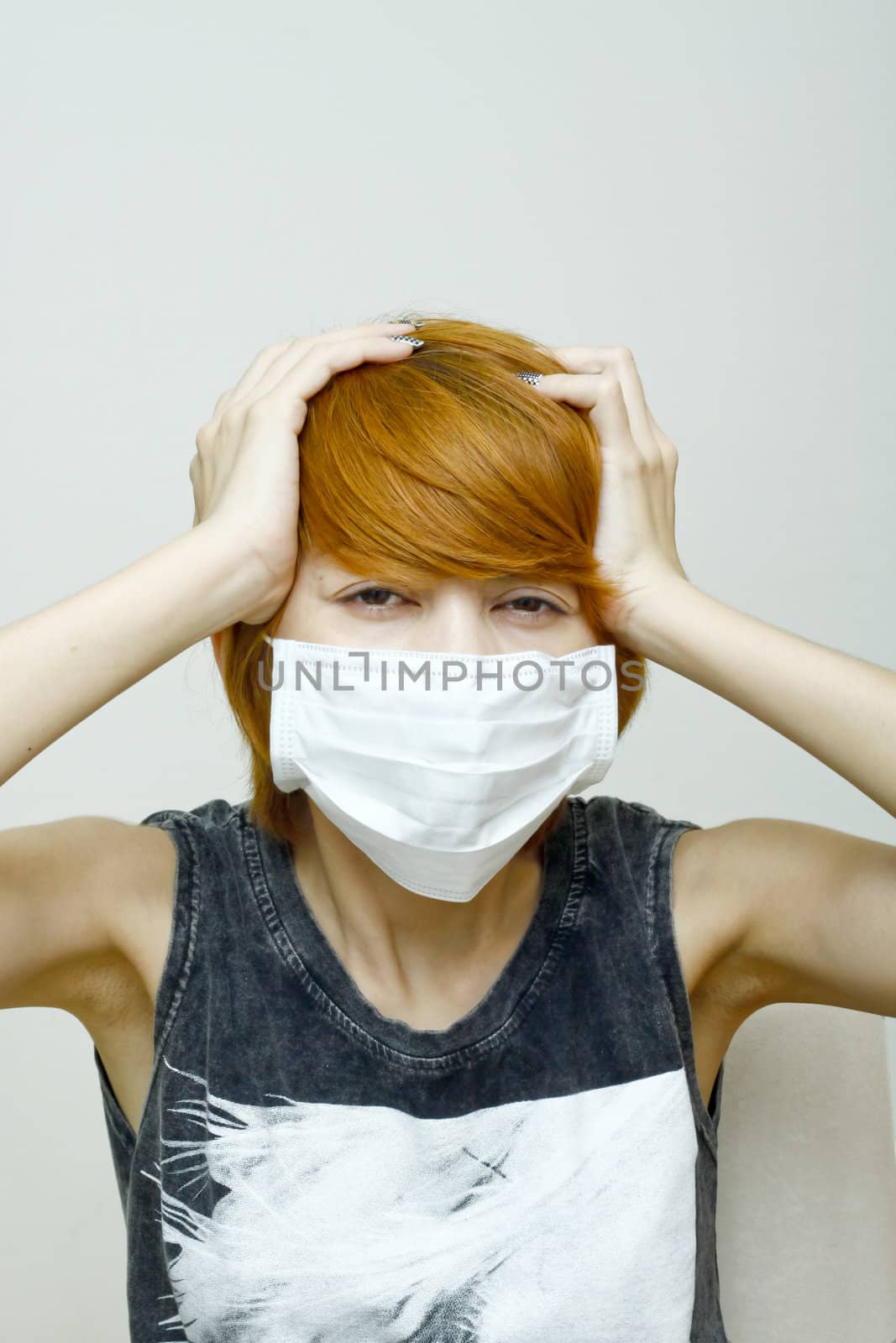 Woman wearing protective mask,Woman with headache holding her hands to the head.