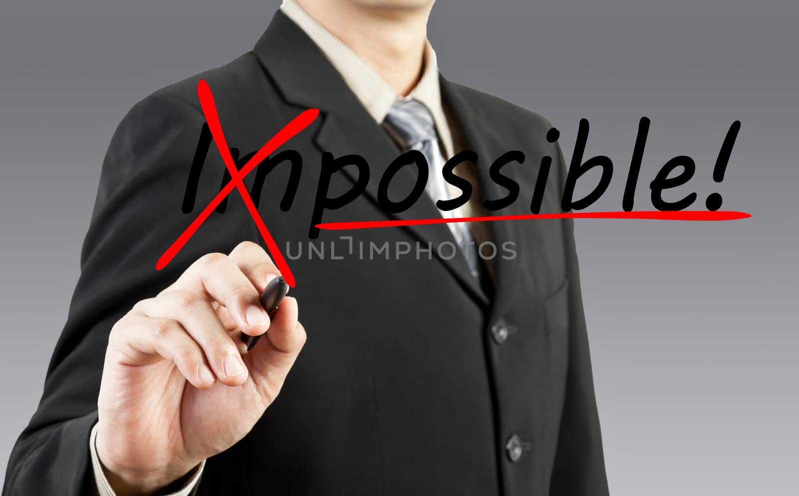 Motivation concept. Businessman changing the word impossible into possible