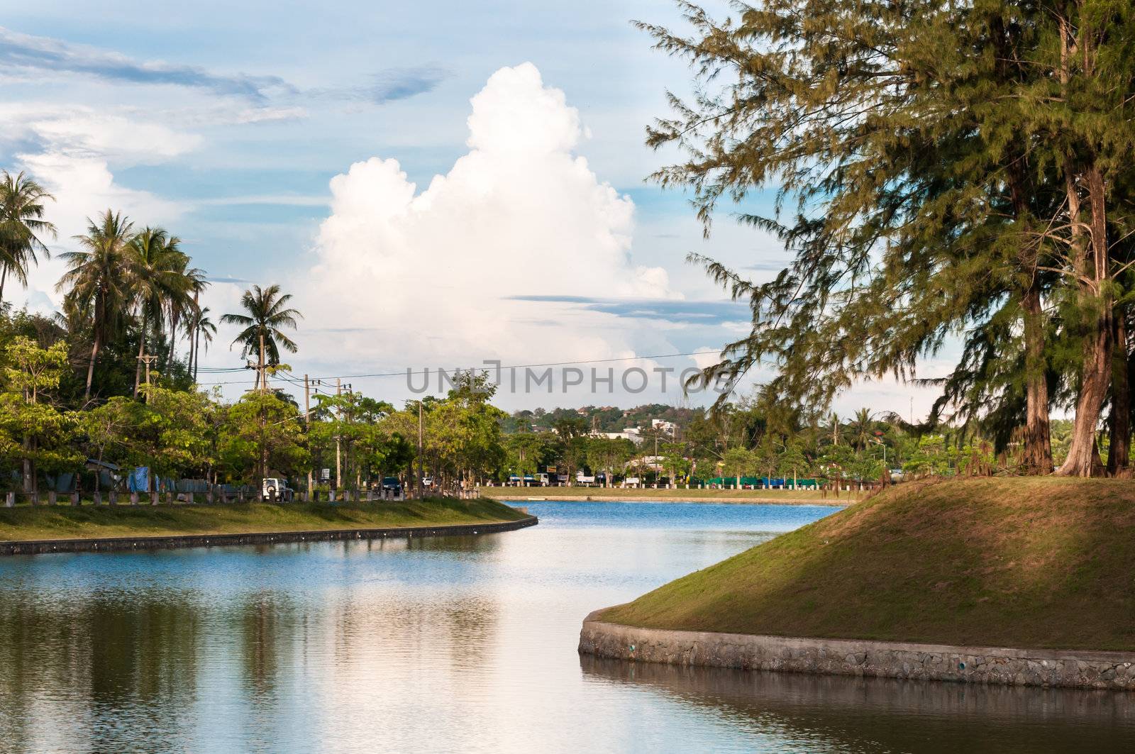 Peaceful lake in tropical town with cloudy sky