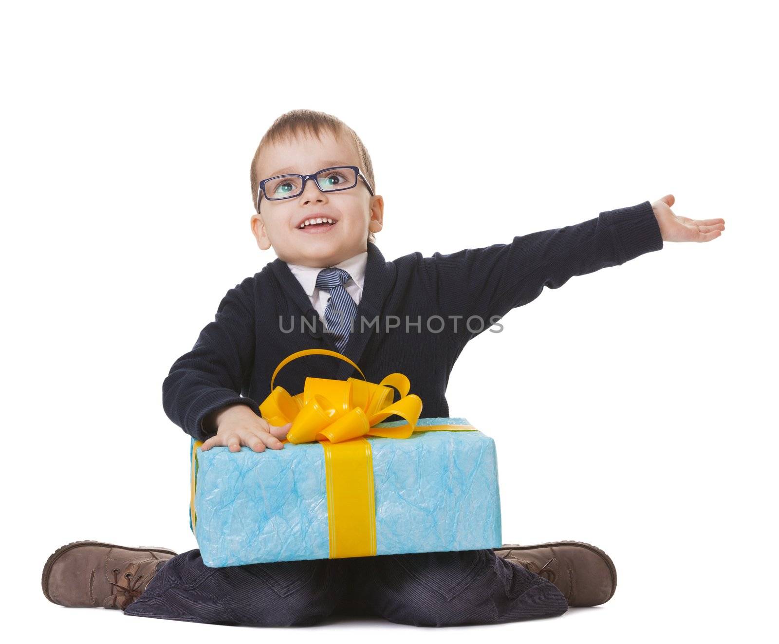 Small sitting boy in spectacles with big present on white background