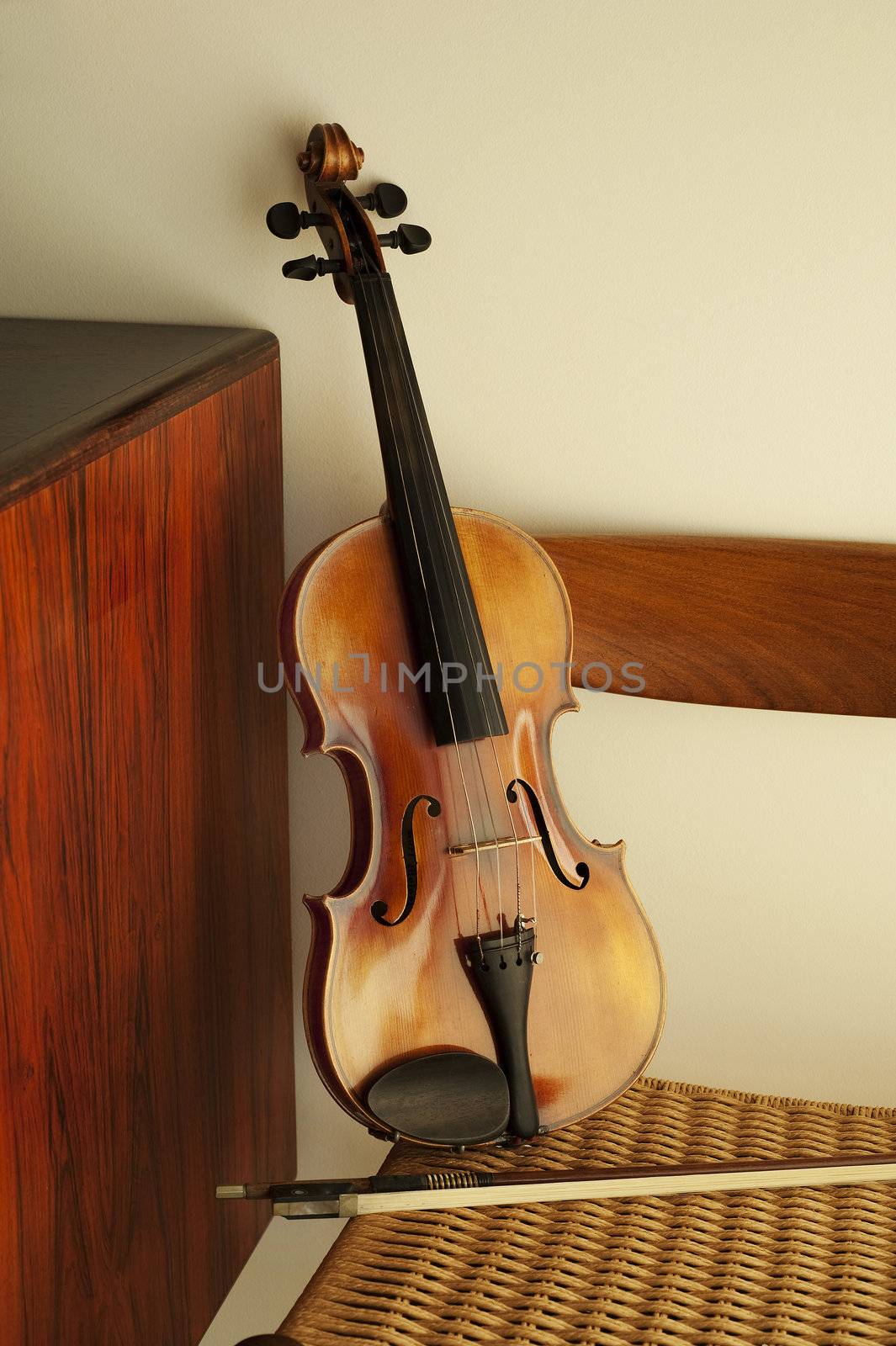 Violin leaning against rope chair