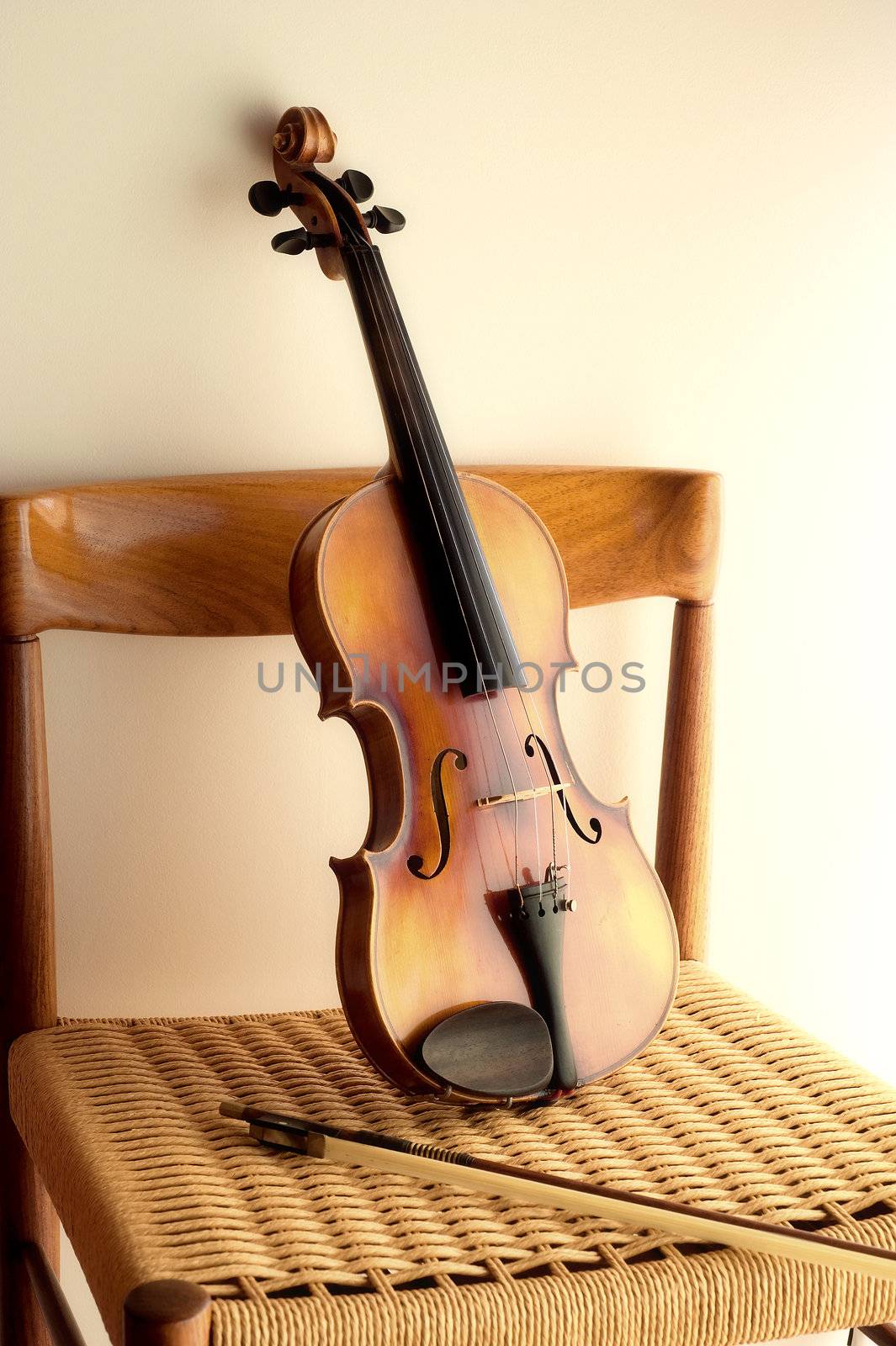Violin leaning against rope chair