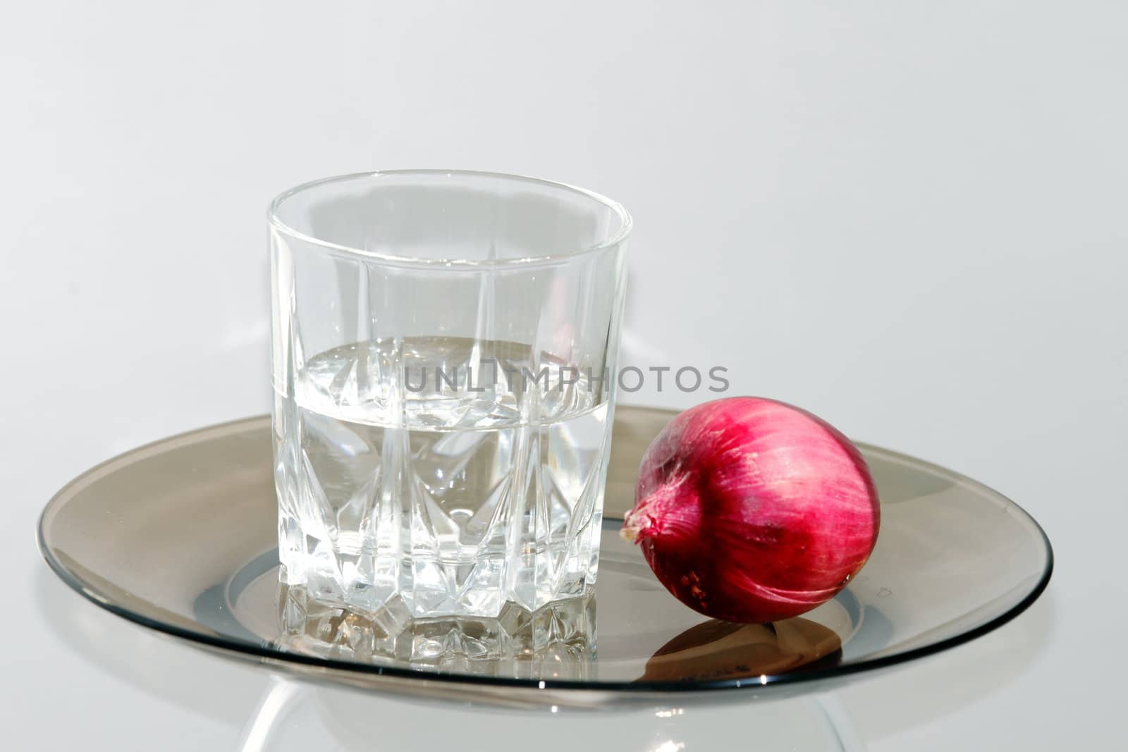 a glass of vodka and on a dark plate on a white background