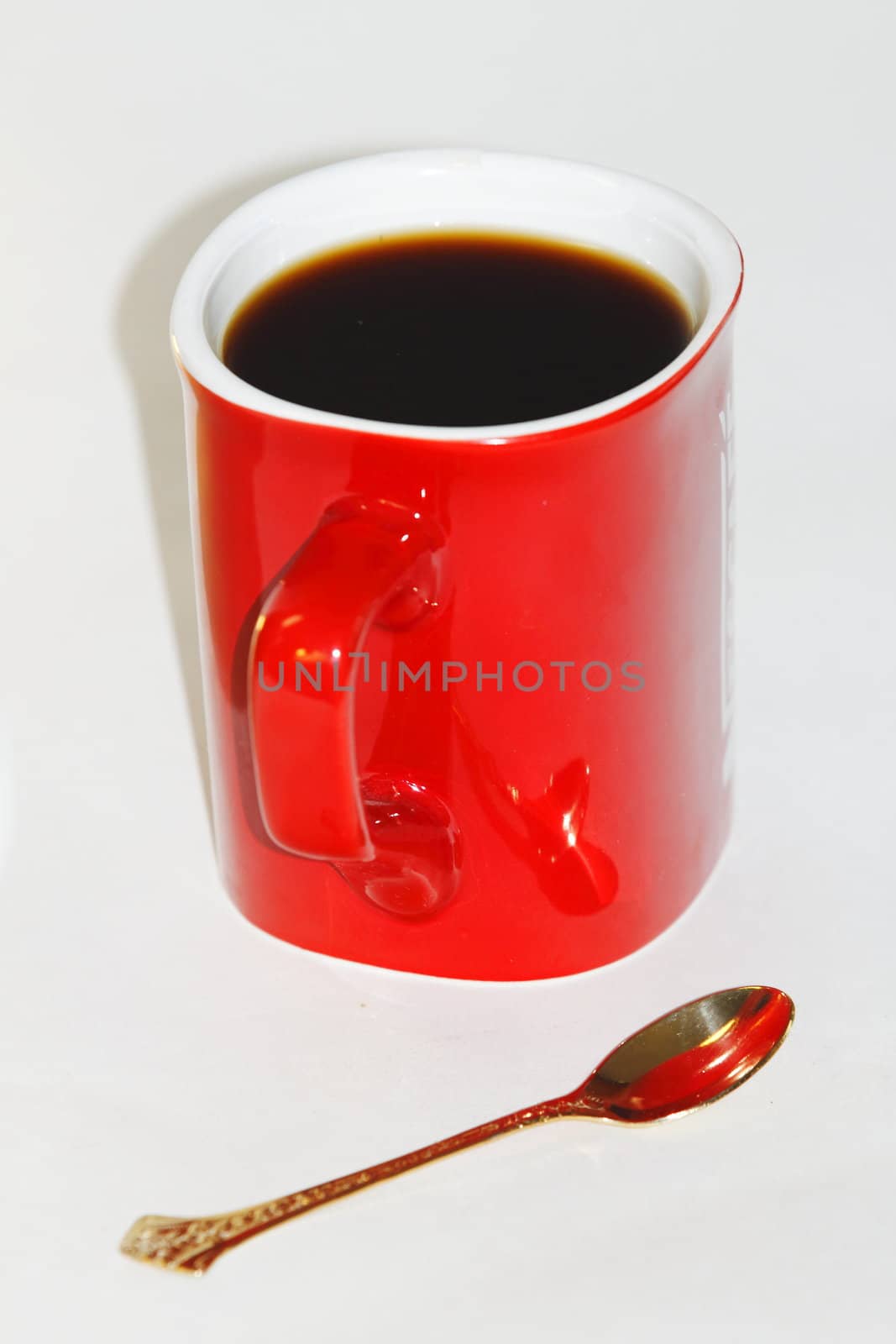 cup of coffee, a gold spoon on white background