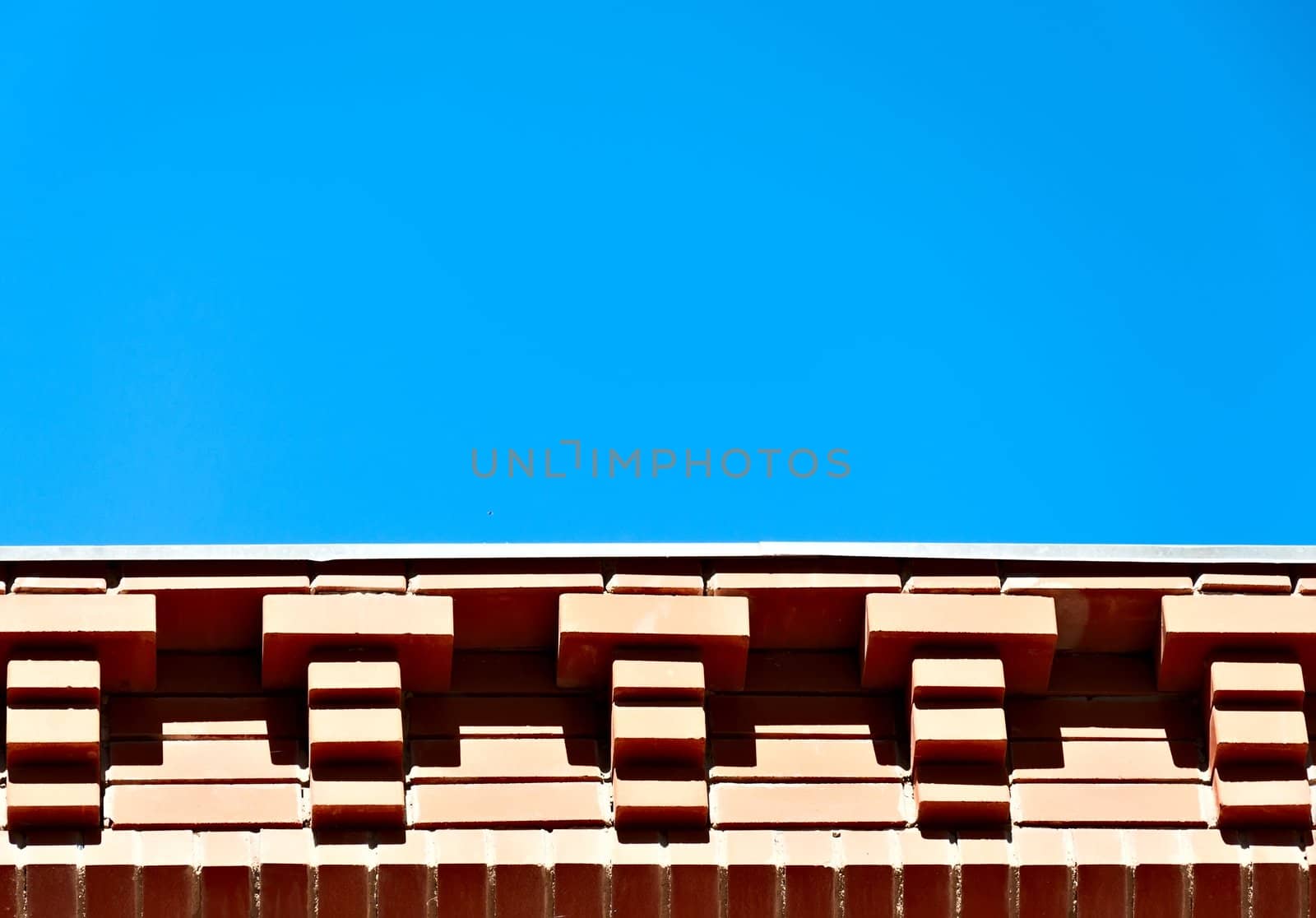 Architectural background - brick eaves against the blue sky.