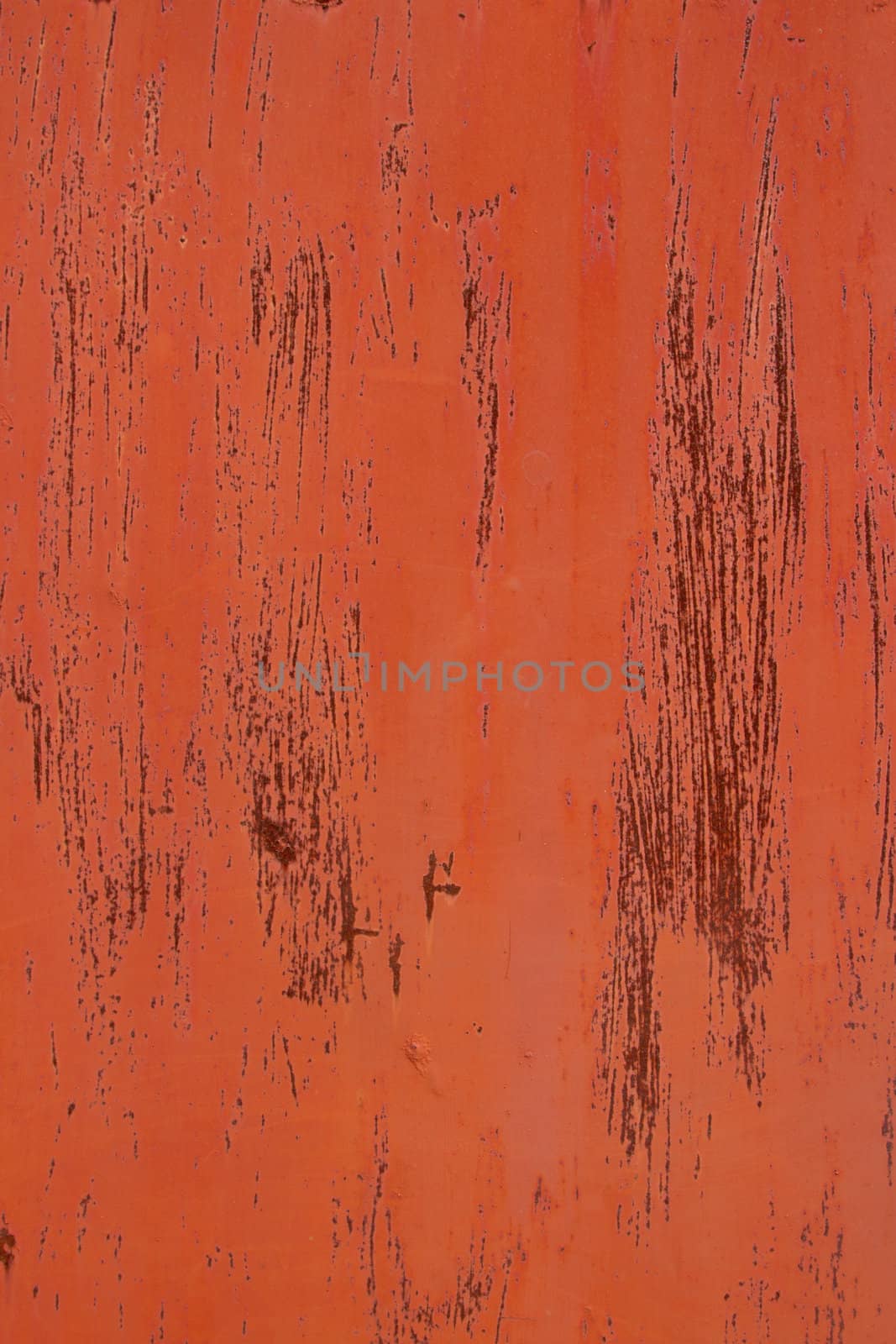 A metal base with orange paint and streaks over rust red.