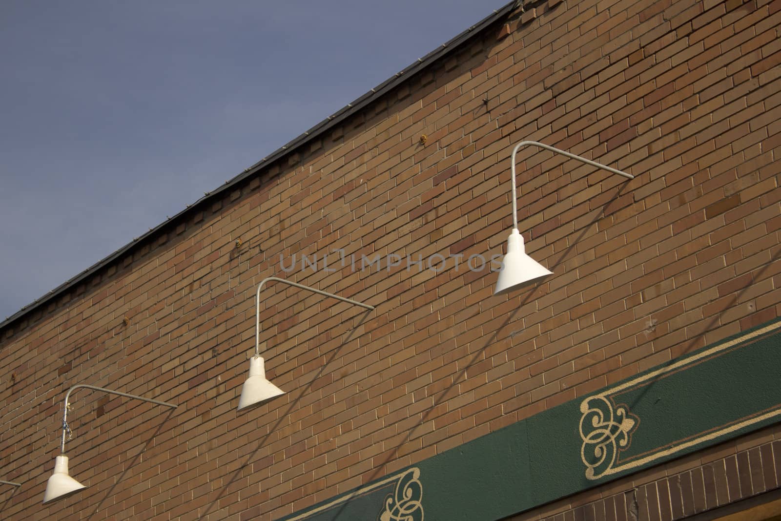 exterior store front lights with a brick wall and blue skies.