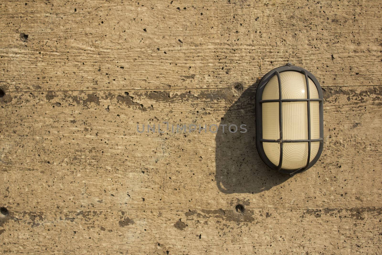 A wall light on a distressed cement or wood wall