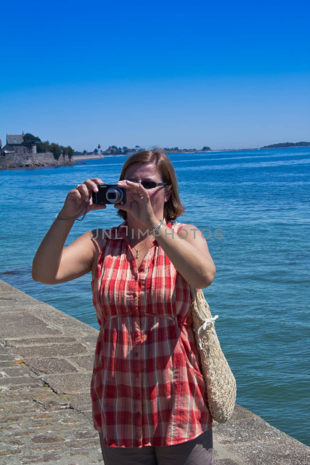 A Tourist taking holiday snaps at the shore