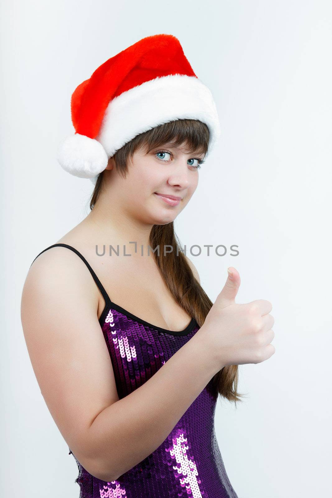 Fancy an attractive girl in a Christmas hat with thumb up