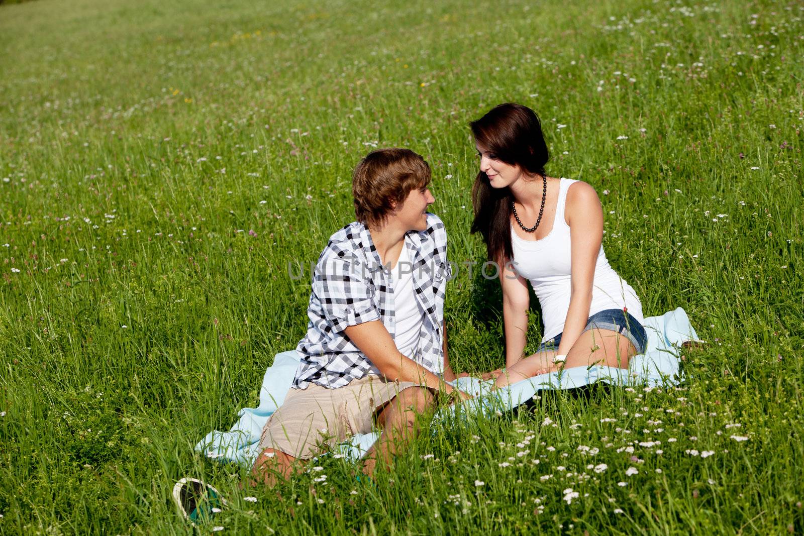 young couple outdoor in summer on blanket in love