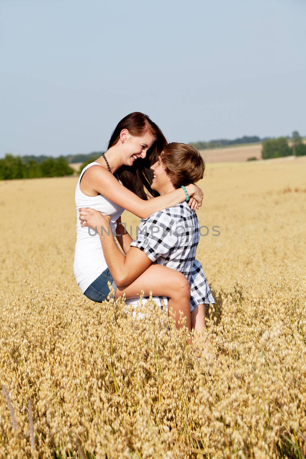 happy couple in love outdoor in summer on field having fun