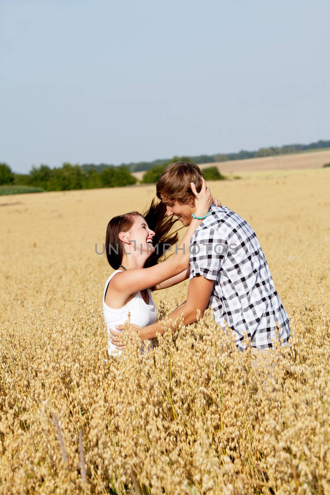 happy couple in love outdoor in summer on field having fun