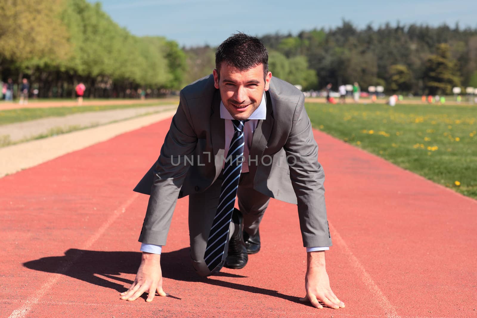 young businessman on running track in summer