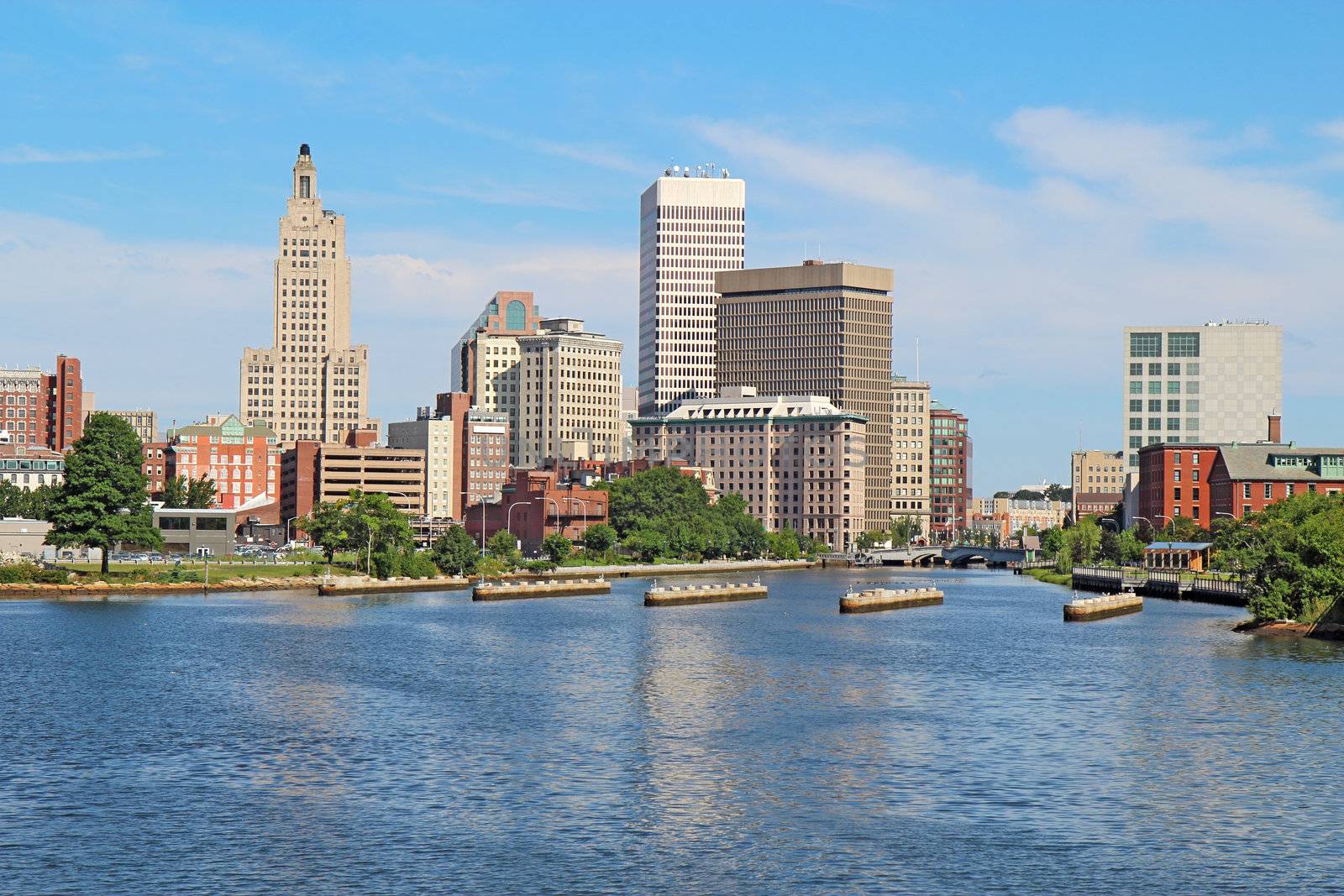 View of the skyline of Providence, Rhode Island, from the far side of the Providence River against a blue sky and white clouds