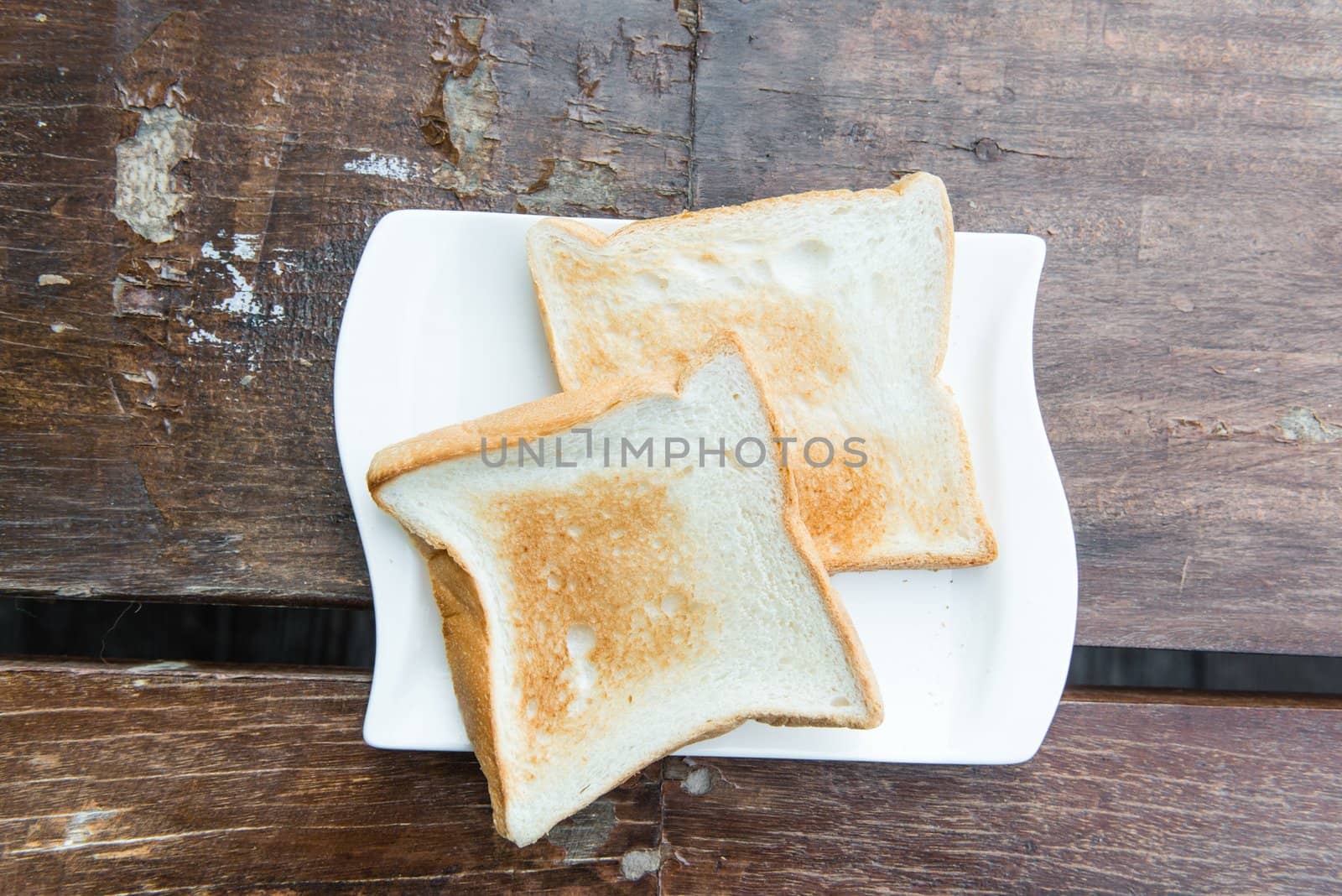 Two toast on a white plate taken from top view out door on a sunny day