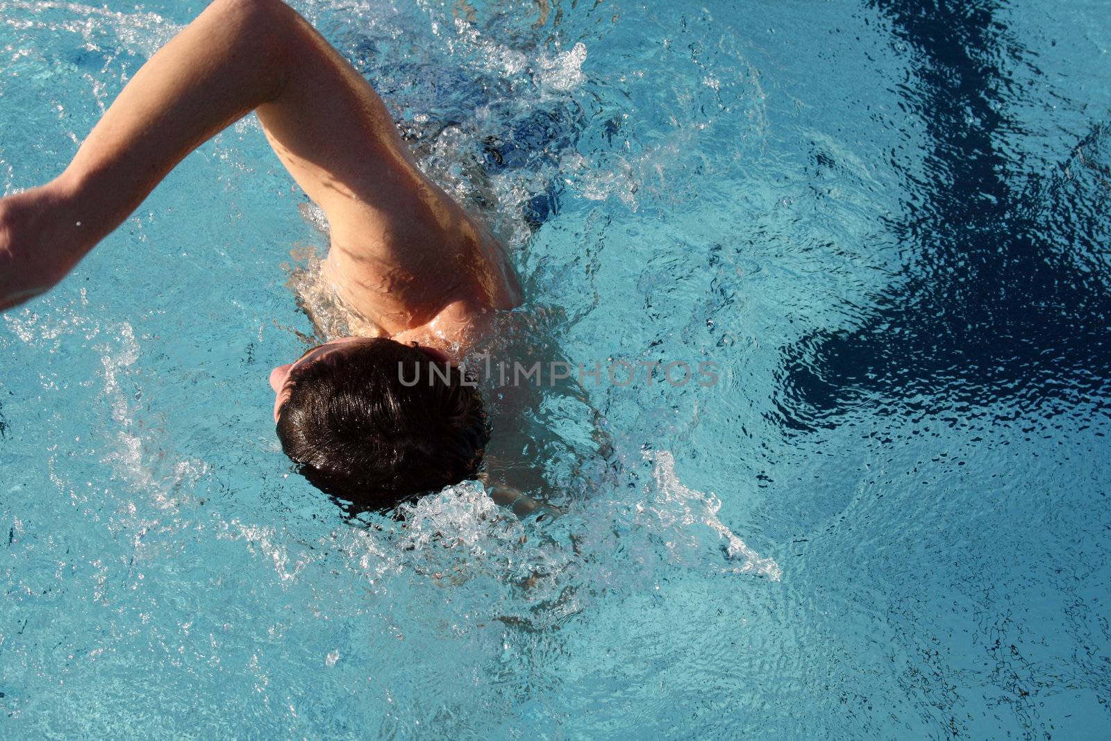 man swims in swimming pool