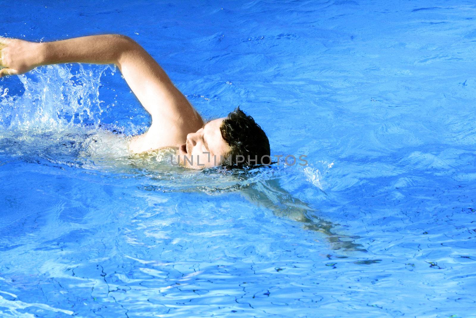 man floats in pool   by photochecker