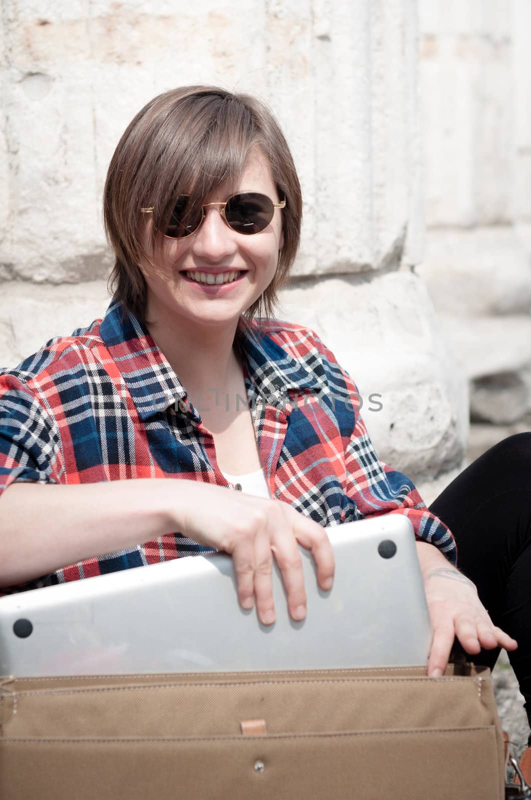 young woman using notebook in the street