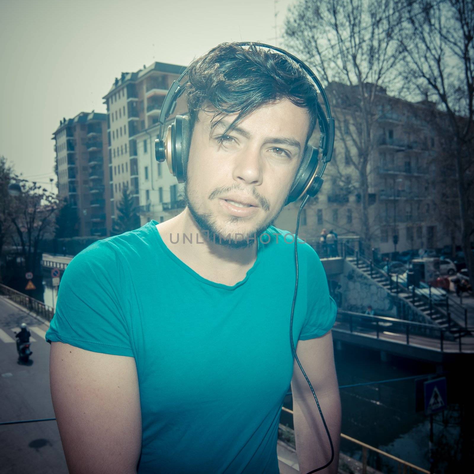 young man hipster listening to music with headphones