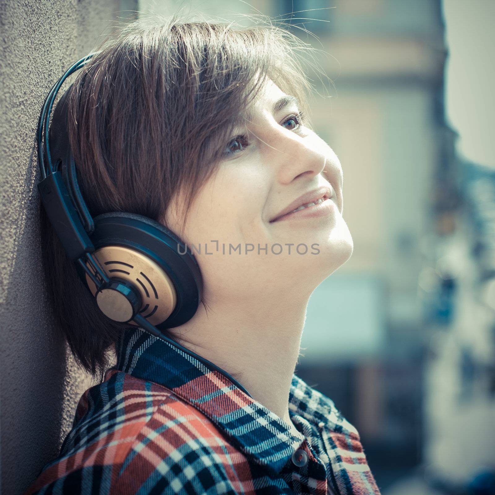 young hipster woman listening to music by peus