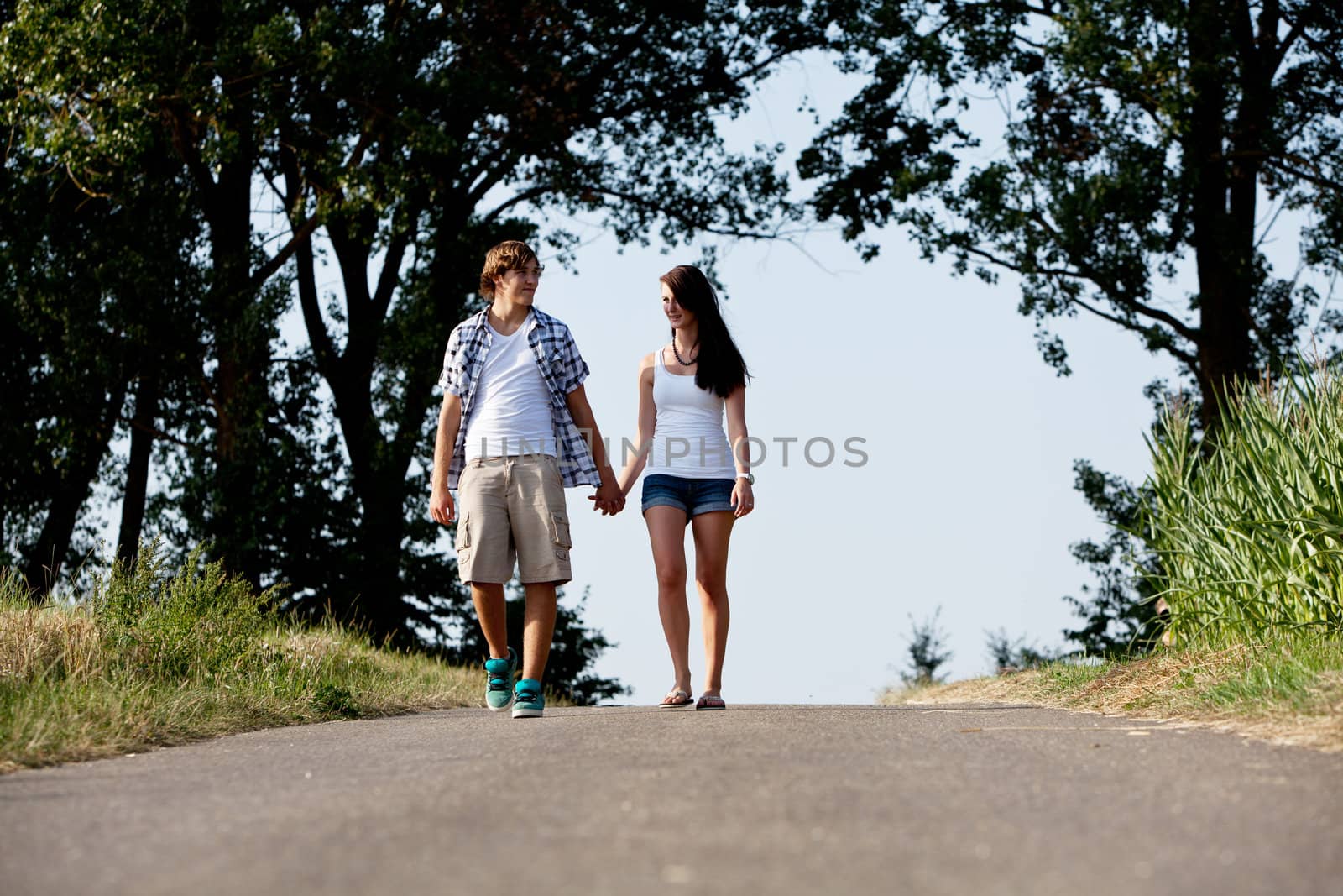 young woman and man is walking on  a road in summer outdoor happy