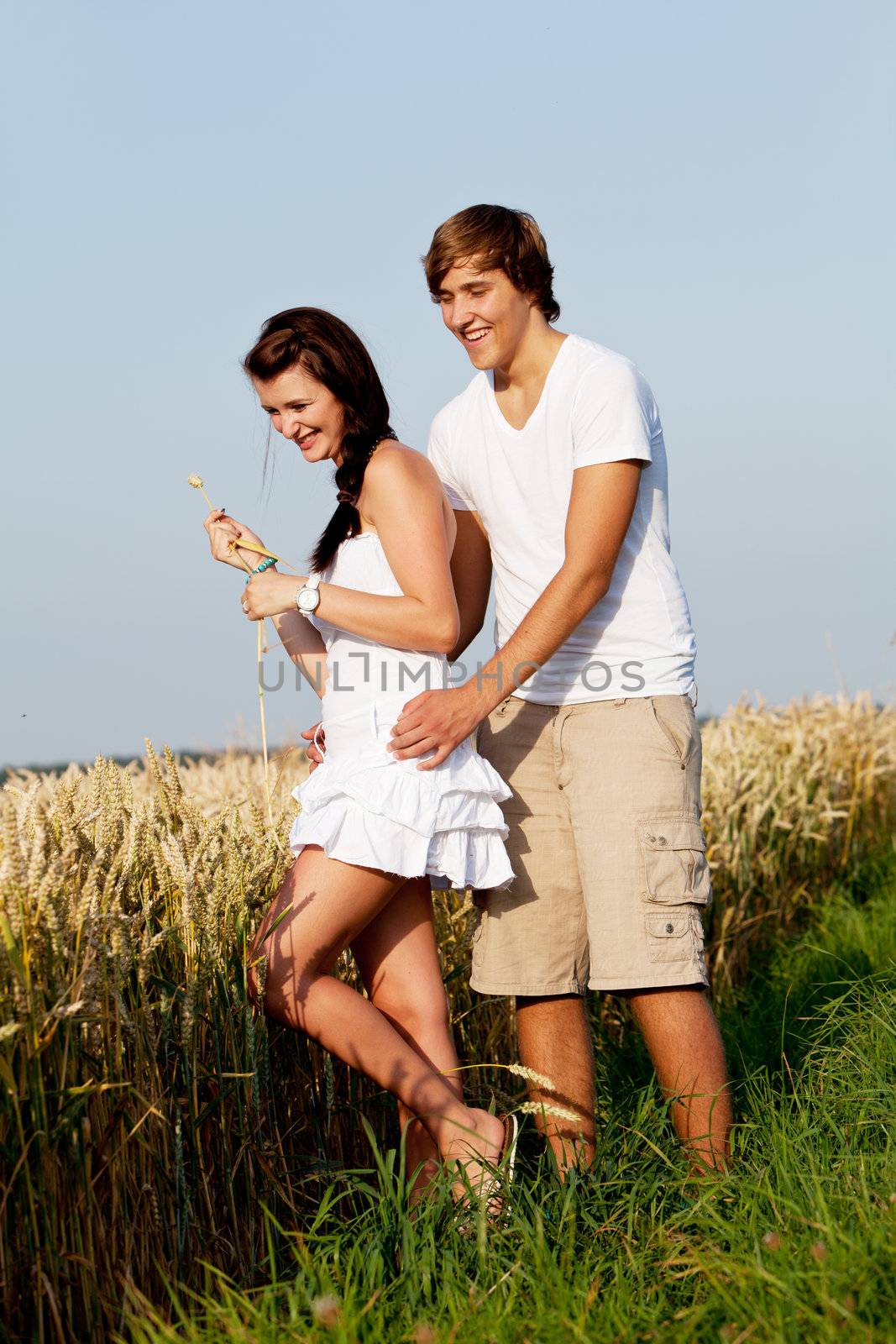 happy couple in love outdoor in summer on field having fun