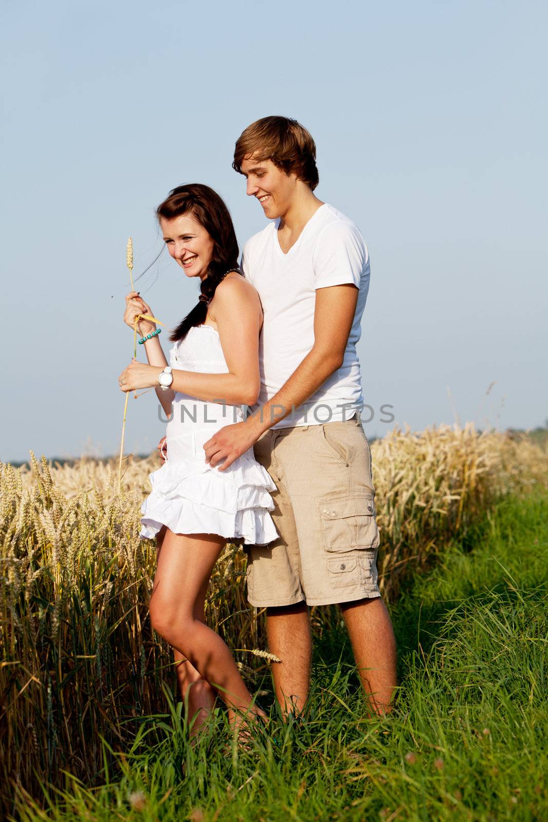happy couple in love outdoor in summer on field having fun