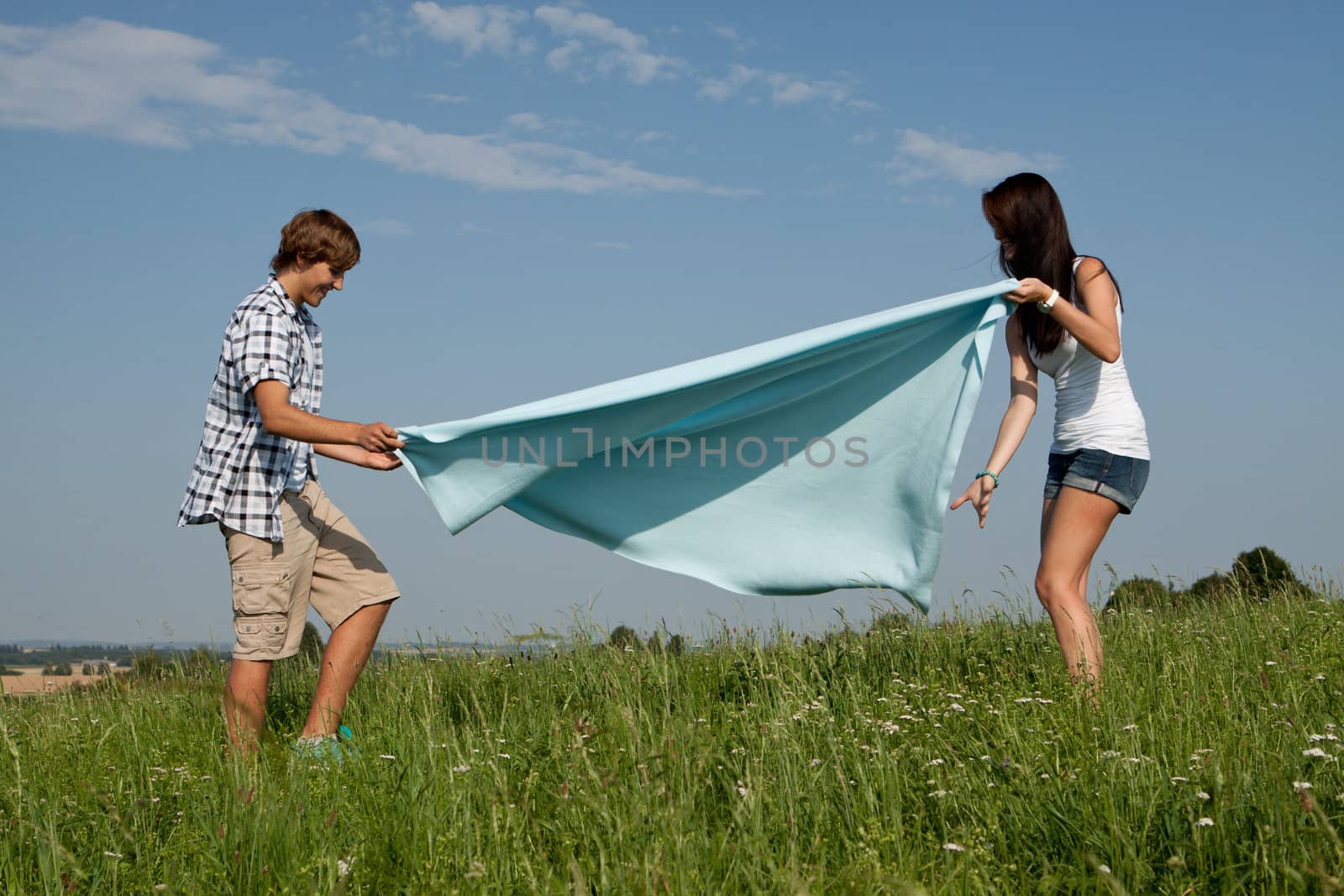 young couple outdoor in summer on blanket in love