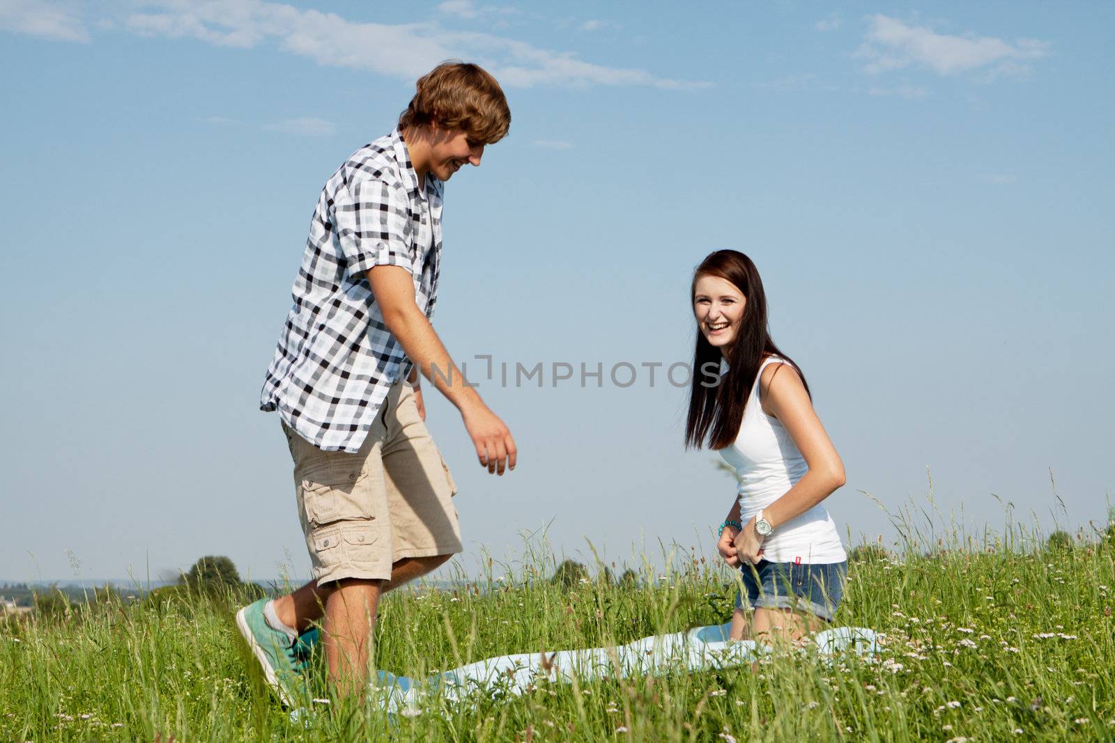 young couple outdoor in summer on blanket in love by juniart