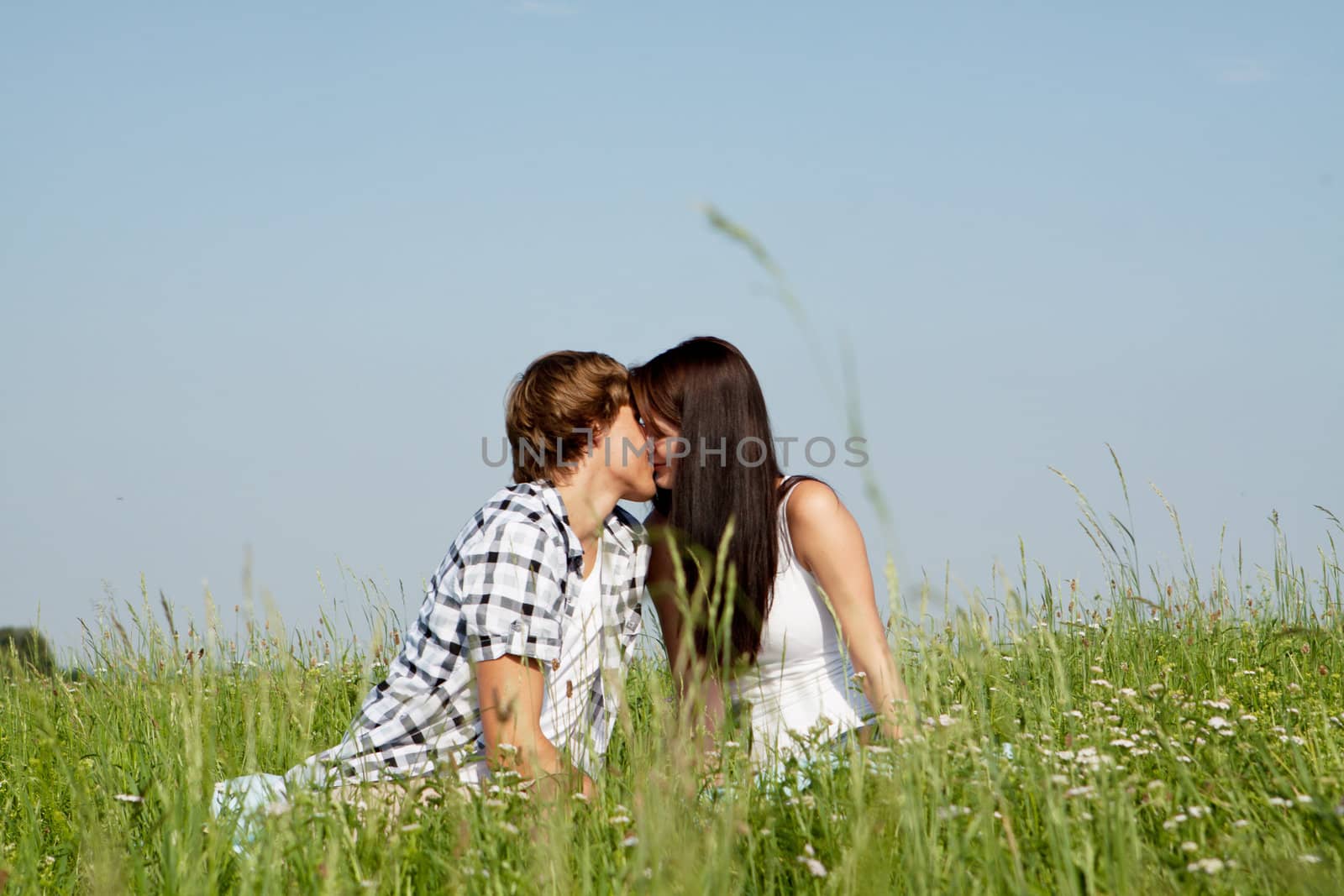young couple outdoor in summer on blanket in love by juniart