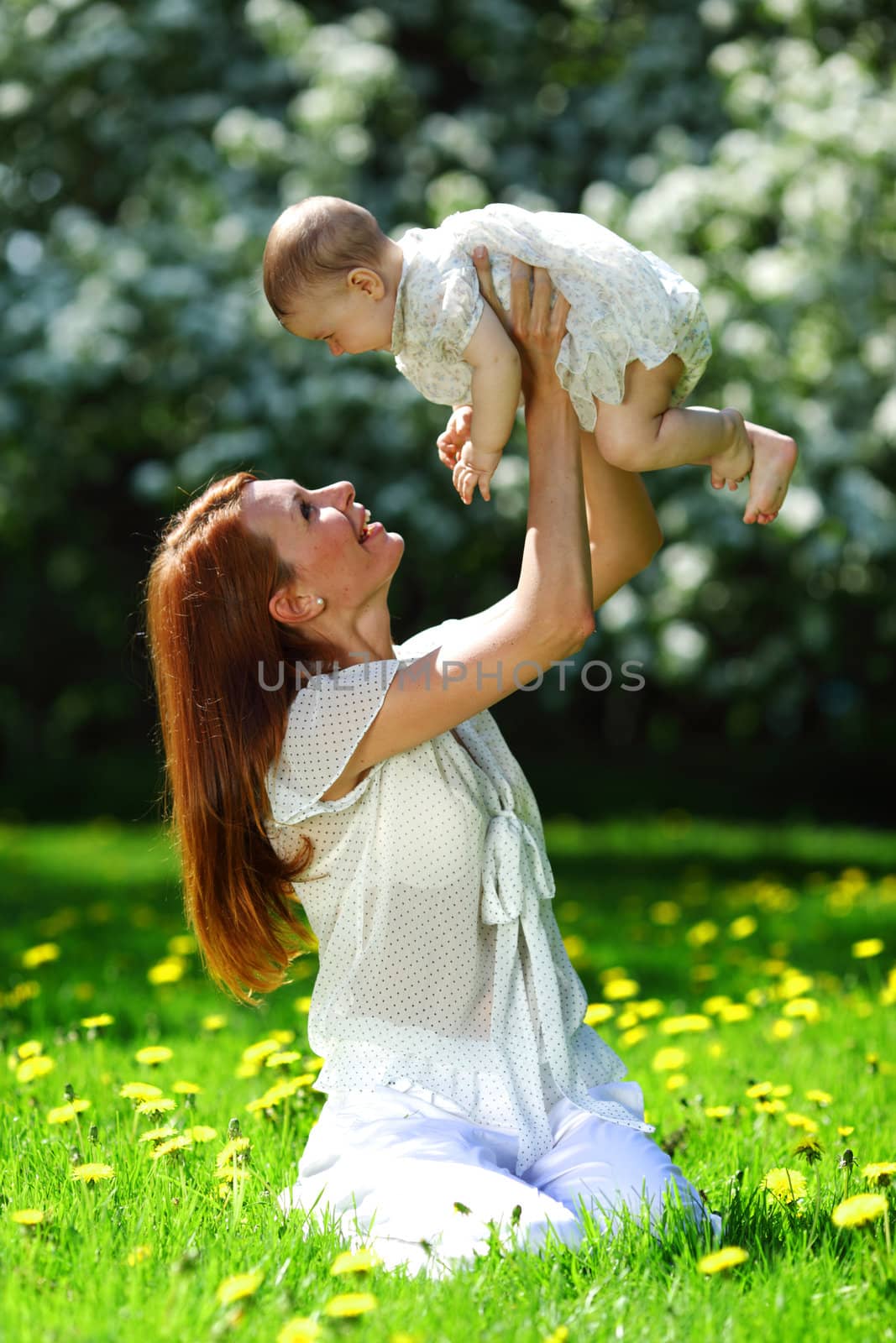 Happy mother and daughter on the green grass