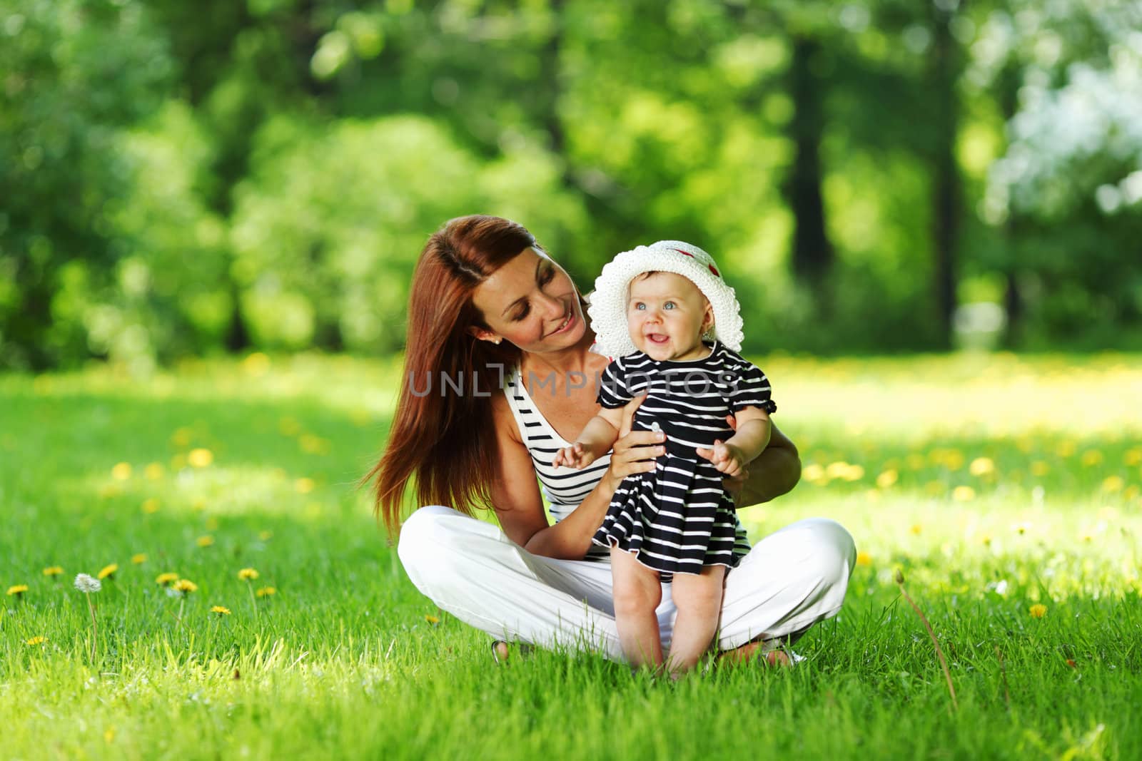 Happy mother and daughter on the green grass