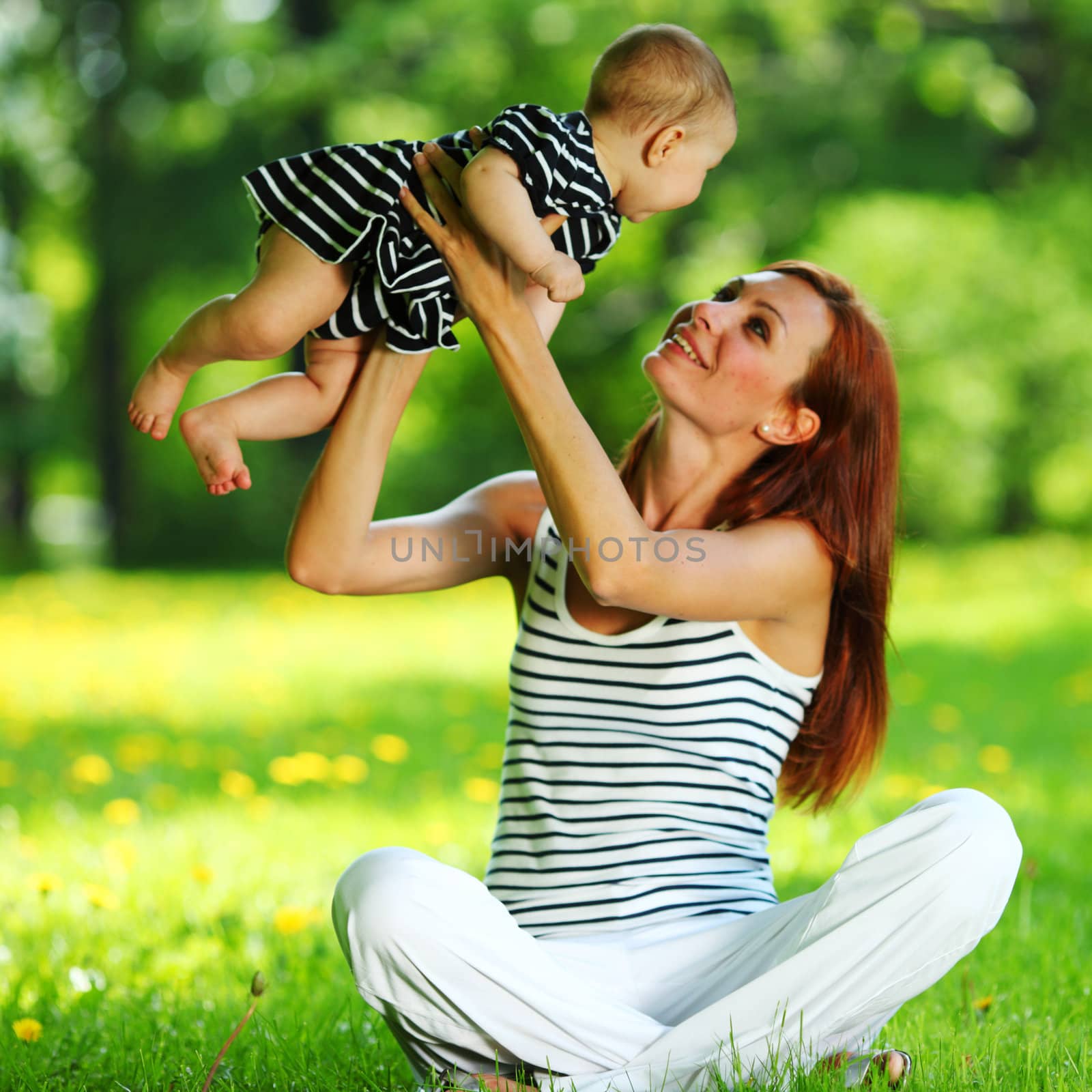 Mother and daughter on the green grass by Yellowj