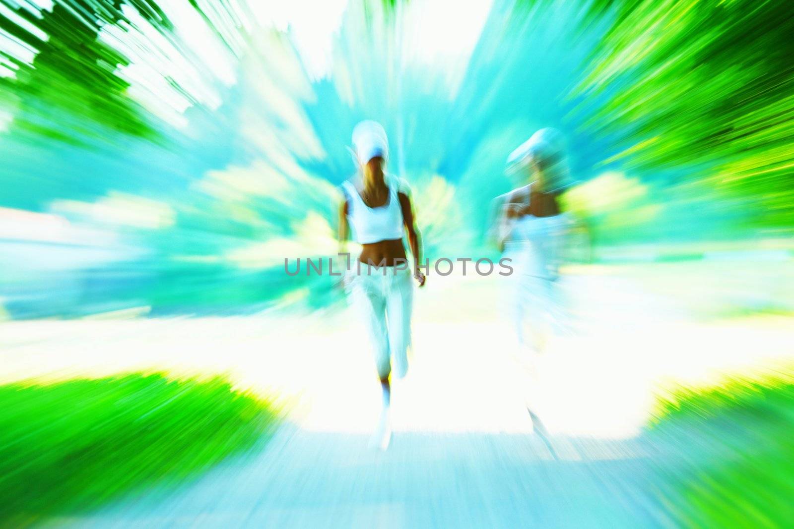 Beautiful young woman running in green park on sunny summer day
