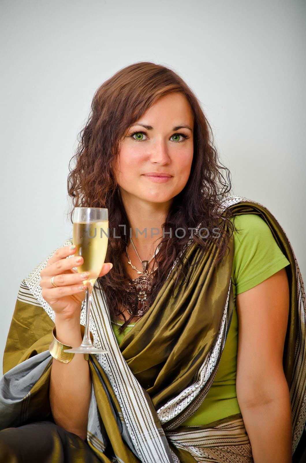 Girl in traditional green clothing with glass of champagne by dmitrimaruta