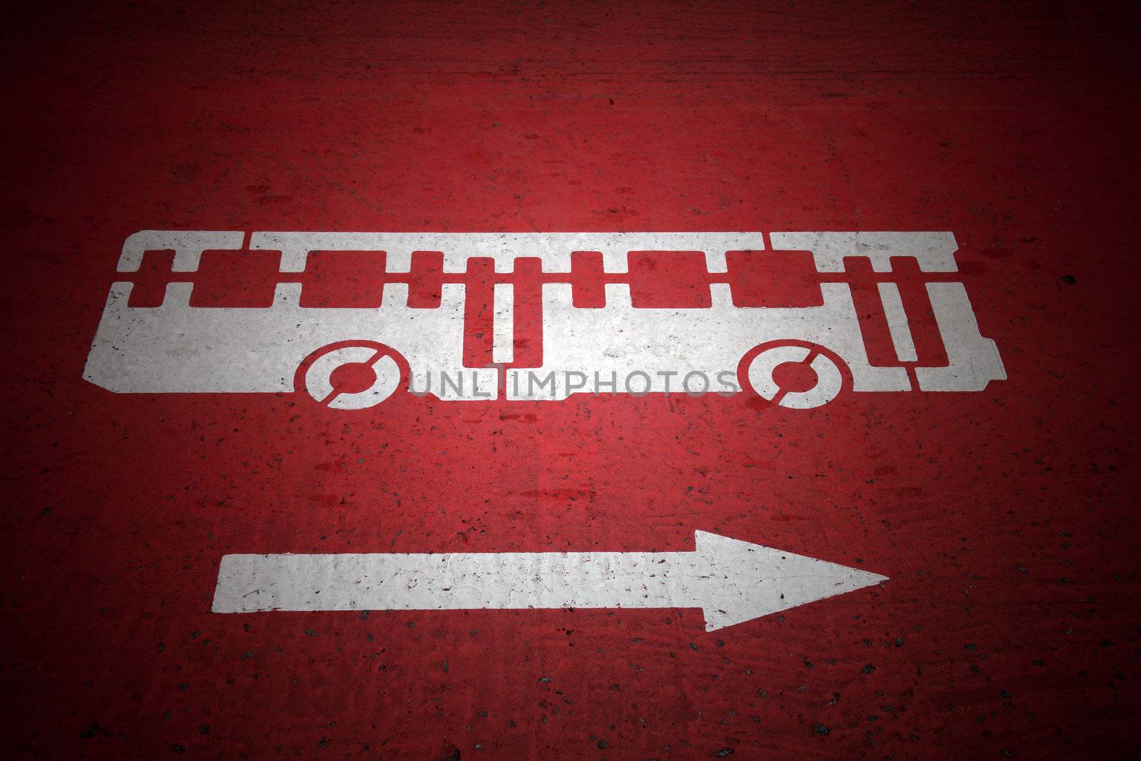  Bus and traffic direction sign painted on red asphalt road