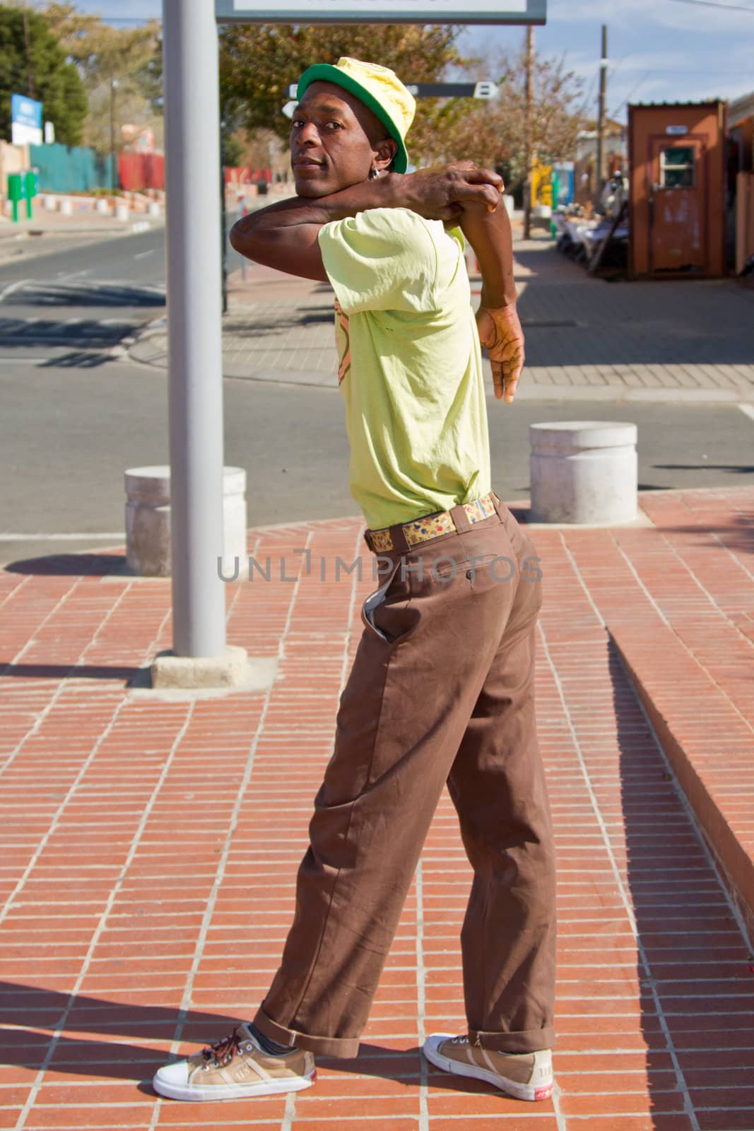 Soweto, South Africa– July 29 – A street performer demonstrates several acrobatic moves showing his body’s unbelievable flexibility near  Mandela’s house on July 29, 2012 in Soweto, South Africa