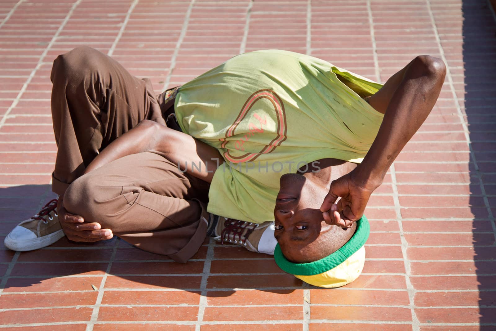 Soweto, South Africa– July 29 – A street performer demonstrates several acrobatic moves showing his body’s unbelievable flexibility near  Mandela’s house on July 29, 2012 in Soweto, South Africa