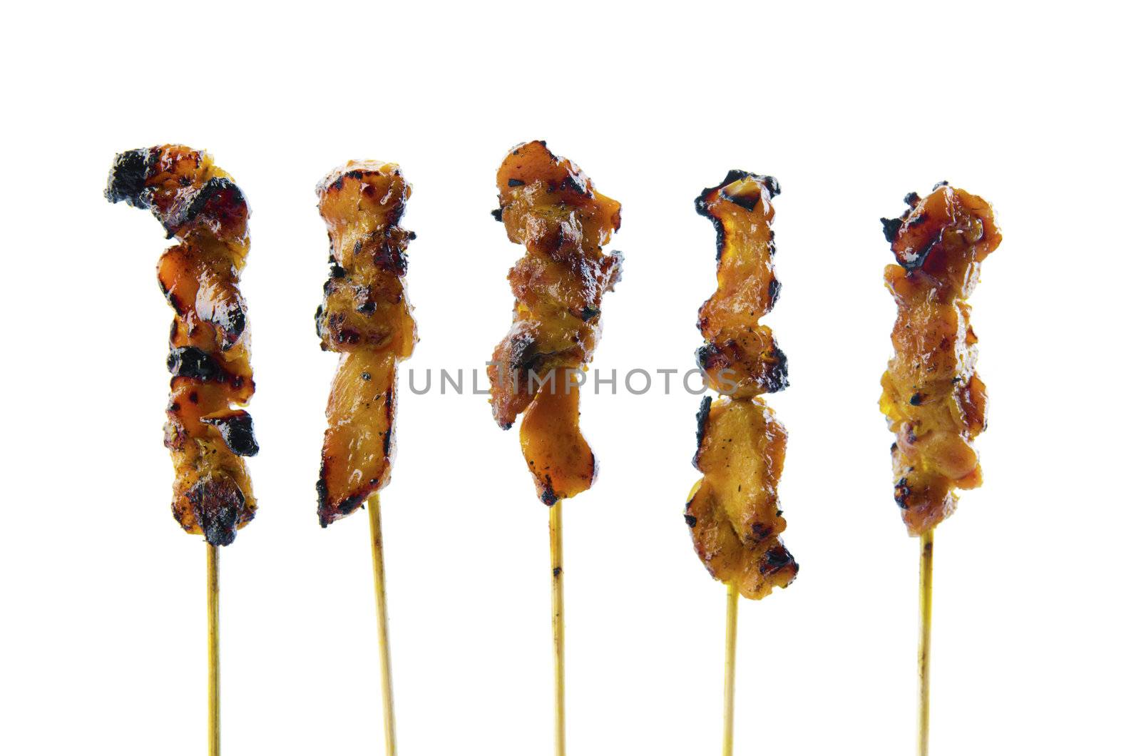 Five satay chicken sticks over white background