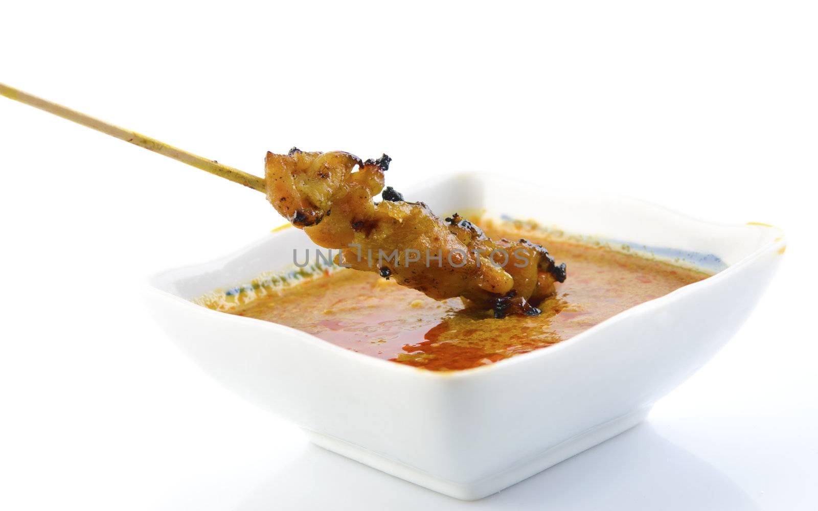 Delicious Satay chicken and peanut sauce over white background