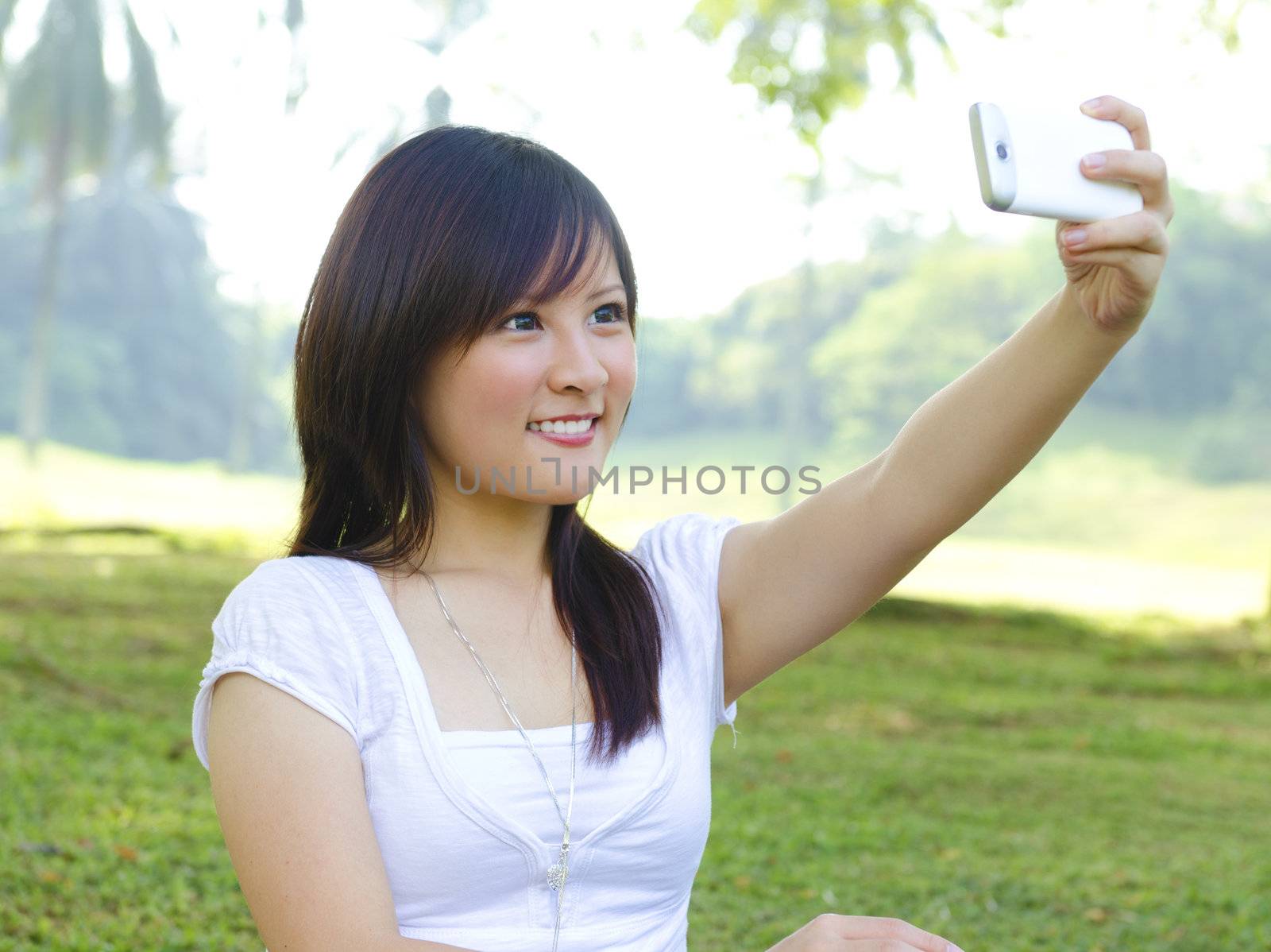 Asian girl self photographing, outdoor green park