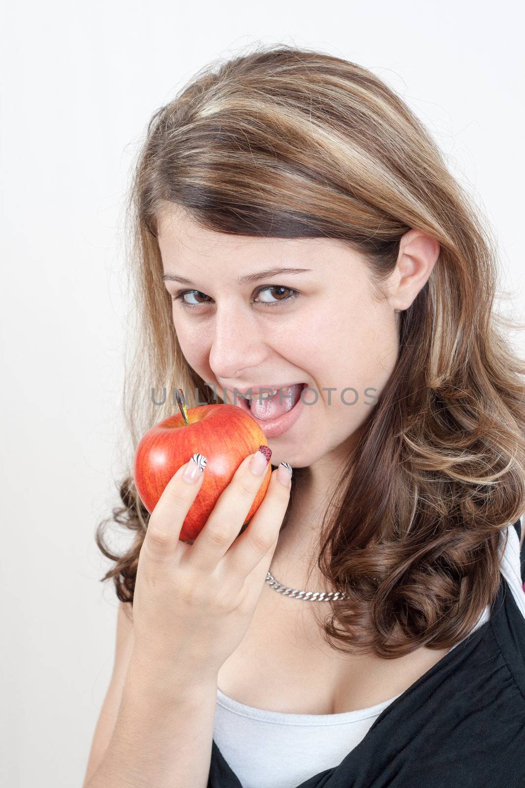 young brunette girl eating a apple on white background