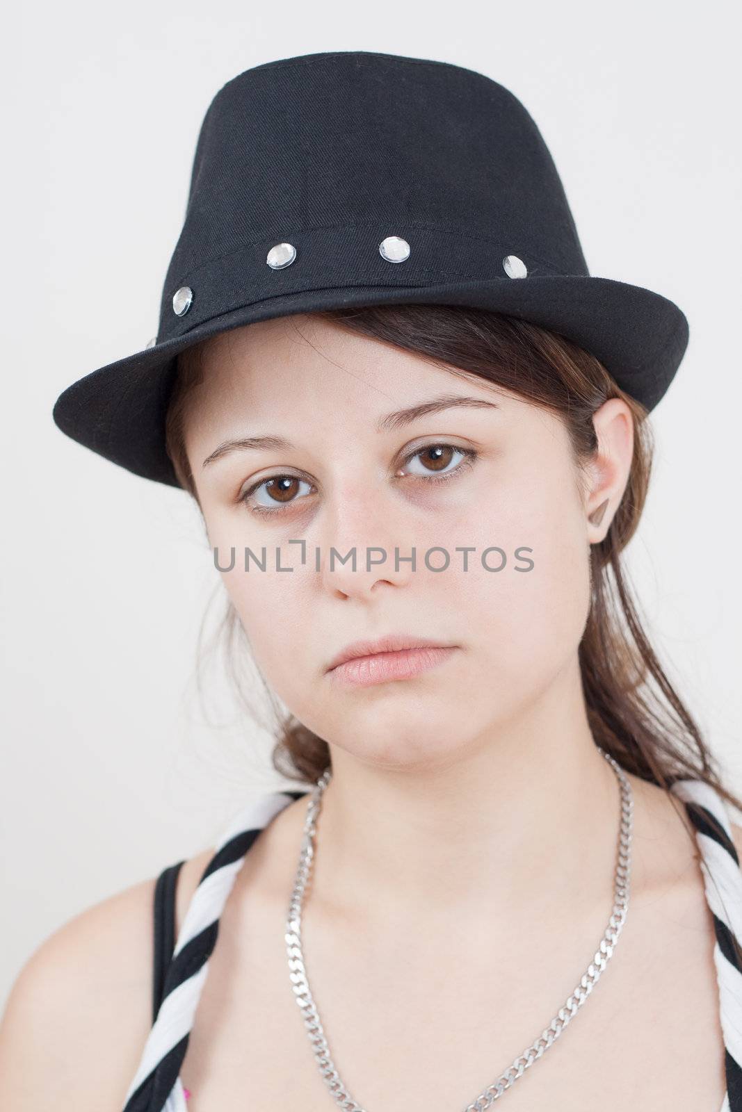 Portrait of young brunette girl wearing a black hat