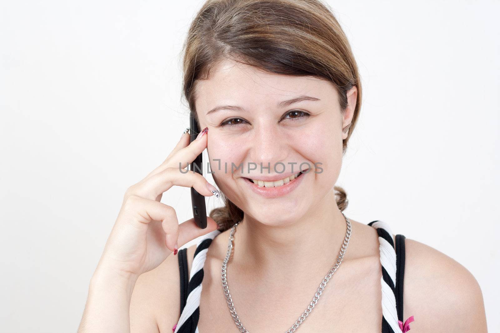 young smiling brunette girl is talking to someone over her smartphone. all on white background