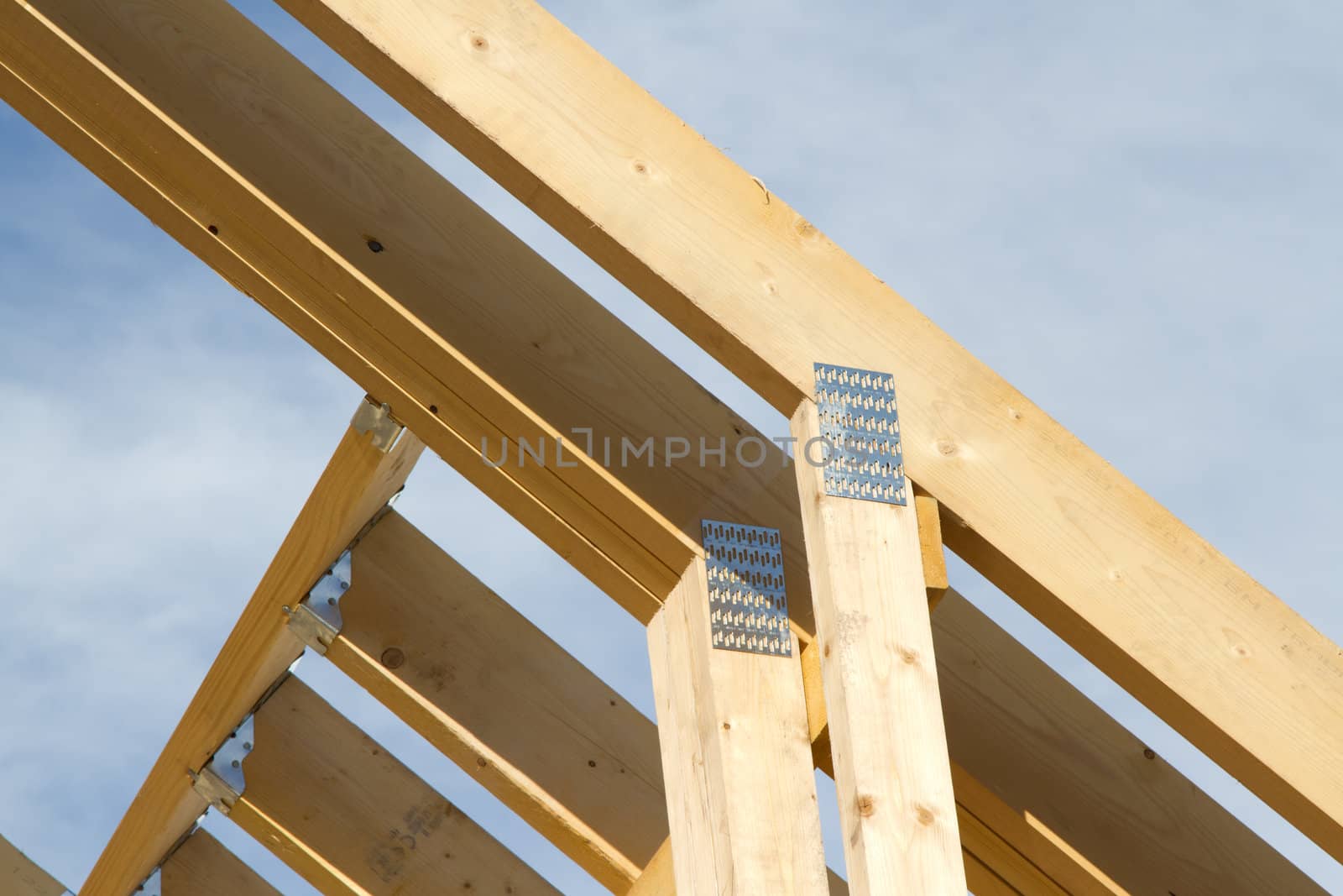 A wooden roof truss structure section with metal joiner supports.