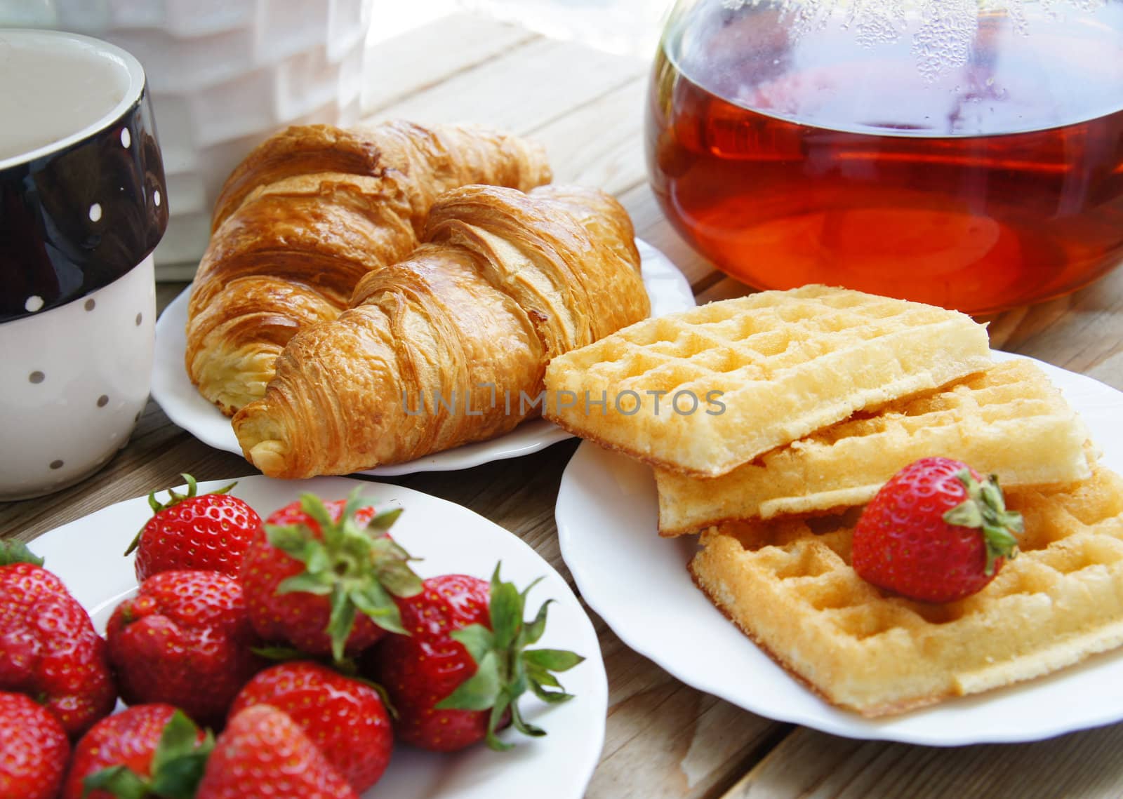 
Tasty breakfast - tea, croissants, wafers with cream and strawberries
                 