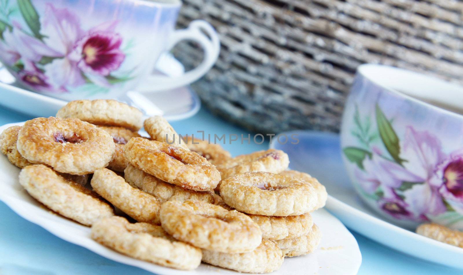 Tea time in the summer garden, tea porcelain cups and biscuits with marmalade 